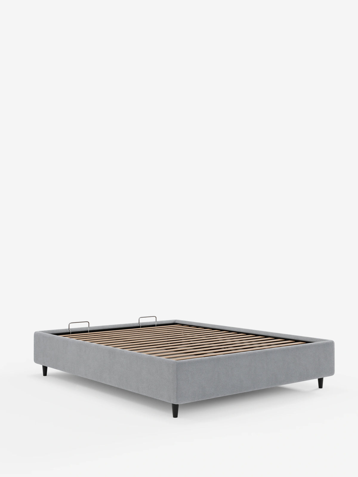 Un letto sommier imbottito ERON grigio con vano contenitore in tessuto impermeabile certificato Oeko-Tex poggia su quattro gambe scure e affusolate, con una base a doghe in legno e due piccole maniglie in metallo, su uno sfondo bianco a tinta unita.