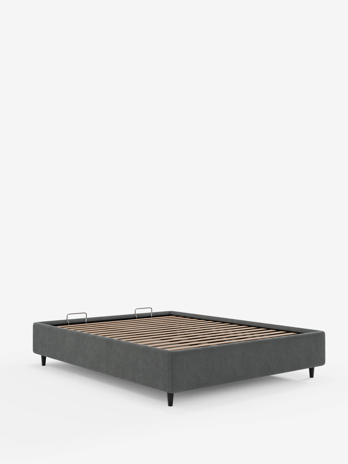 Un letto sommier ERON color grigio antracite, imbottito e dotato di vano contenitore rivestito in tessuto impermeabile certificato Oeko-Tex, con base a doghe in legno, struttura rettangolare imbottita, gambe corte e affusolate di colore scuro e due maniglie in metallo per l’accesso al vano contenitore.