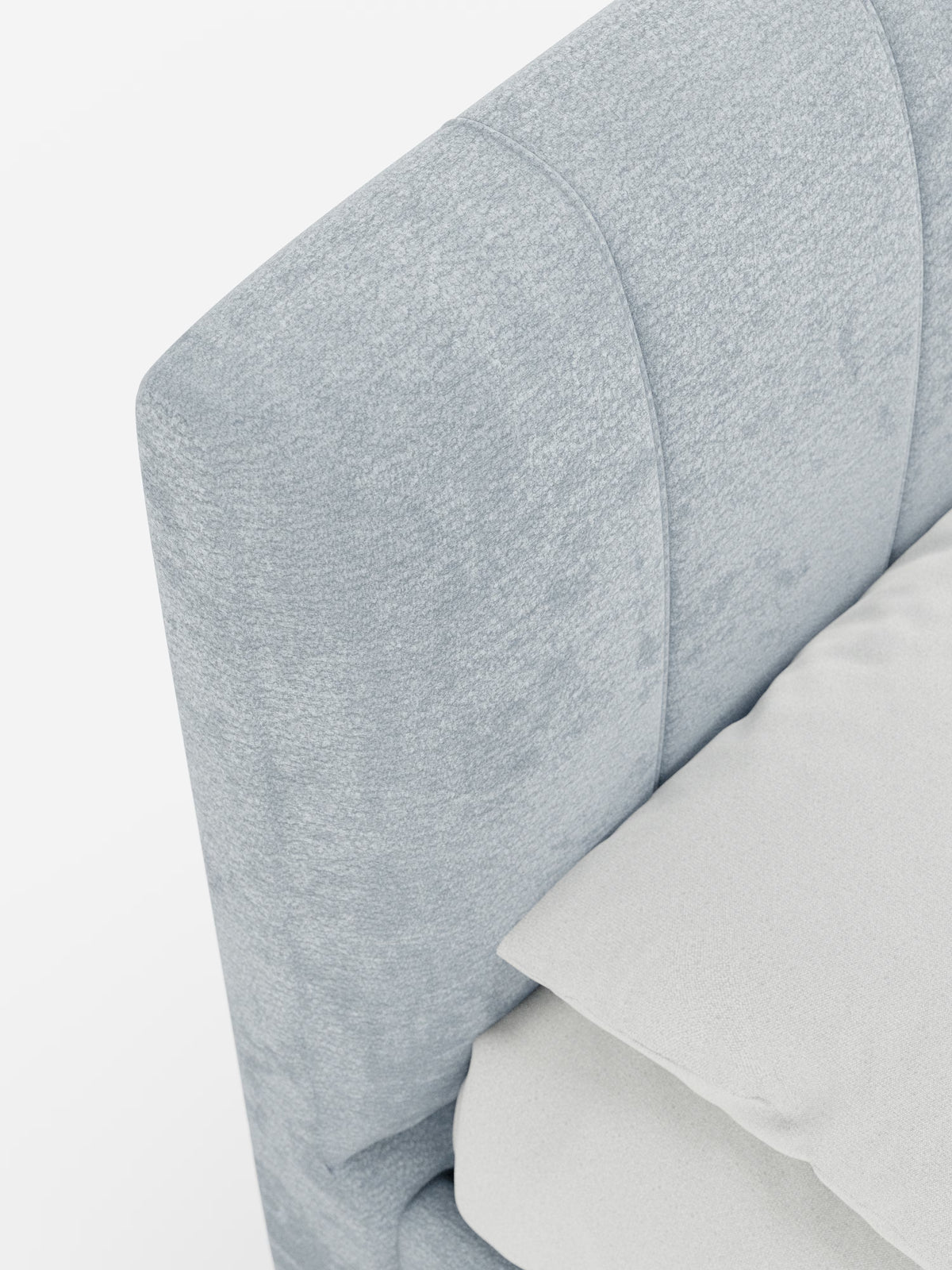 Primo piano del letto imbottito ONYX con contenitore e testiera verticale in tessuto certificato Oeko-Tex® di Letti.store, caratterizzato da una testiera imbottita grigio chiaro con una morbida trama in tessuto e cuciture verticali. Un cuscino bianco e una parte di un lenzuolo bianco poggiano sul materasso accanto alla testiera. Lo sfondo bianco a tinta unita esalta il design elegante e moderno di questo letto di Letti.store.