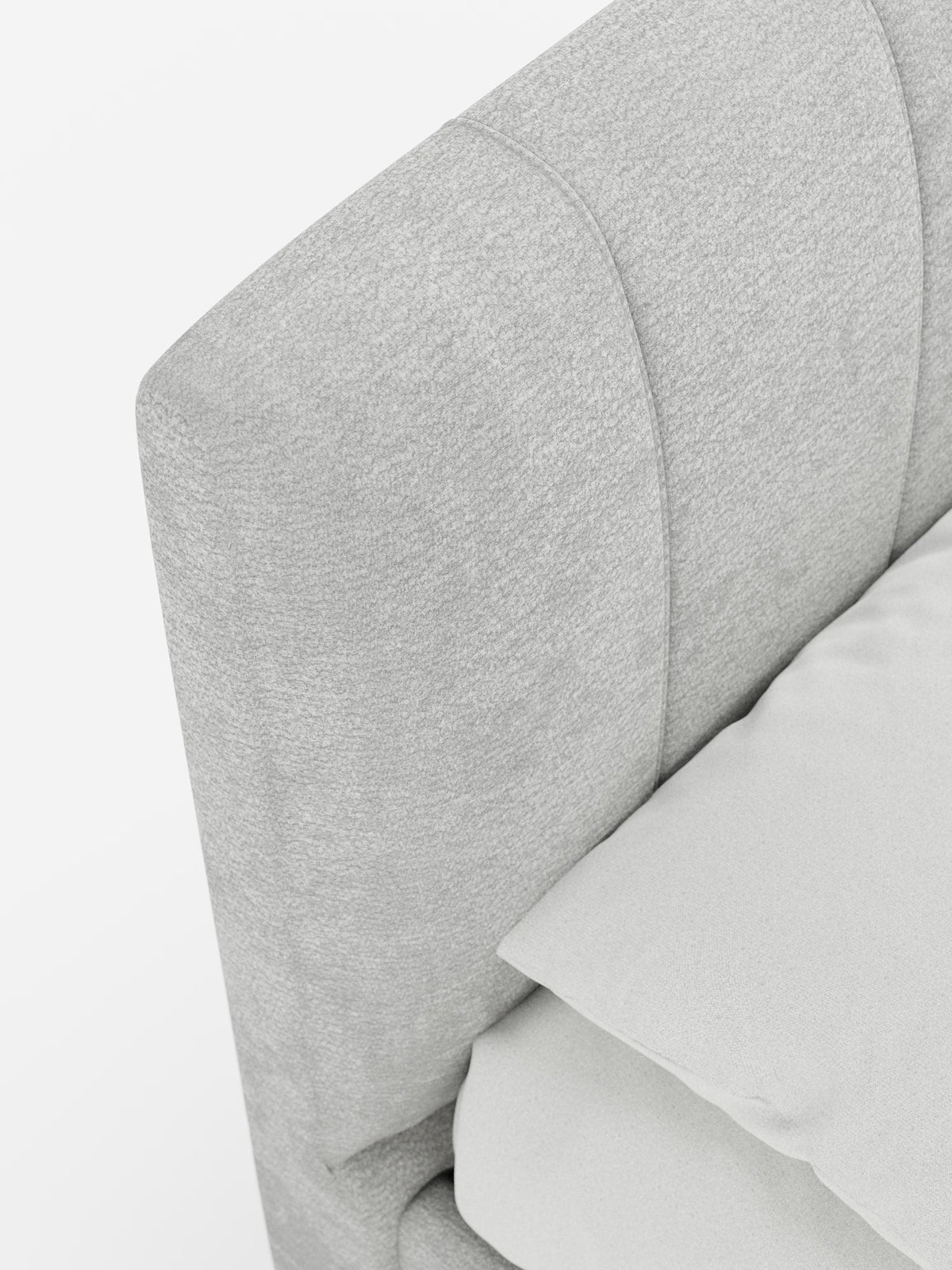Primo piano del letto imbottito ONYX di Letti.store, caratterizzato da un tessuto grigio chiaro certificato Oeko-Tex® e da una testiera verticale. È parzialmente visibile la struttura abbinata del letto contenitore, insieme a un cuscino e a una coperta color bianco sporco. Sullo sfondo bianco, l’immagine mette in risalto la morbida consistenza del letto e il suo design contemporaneo.