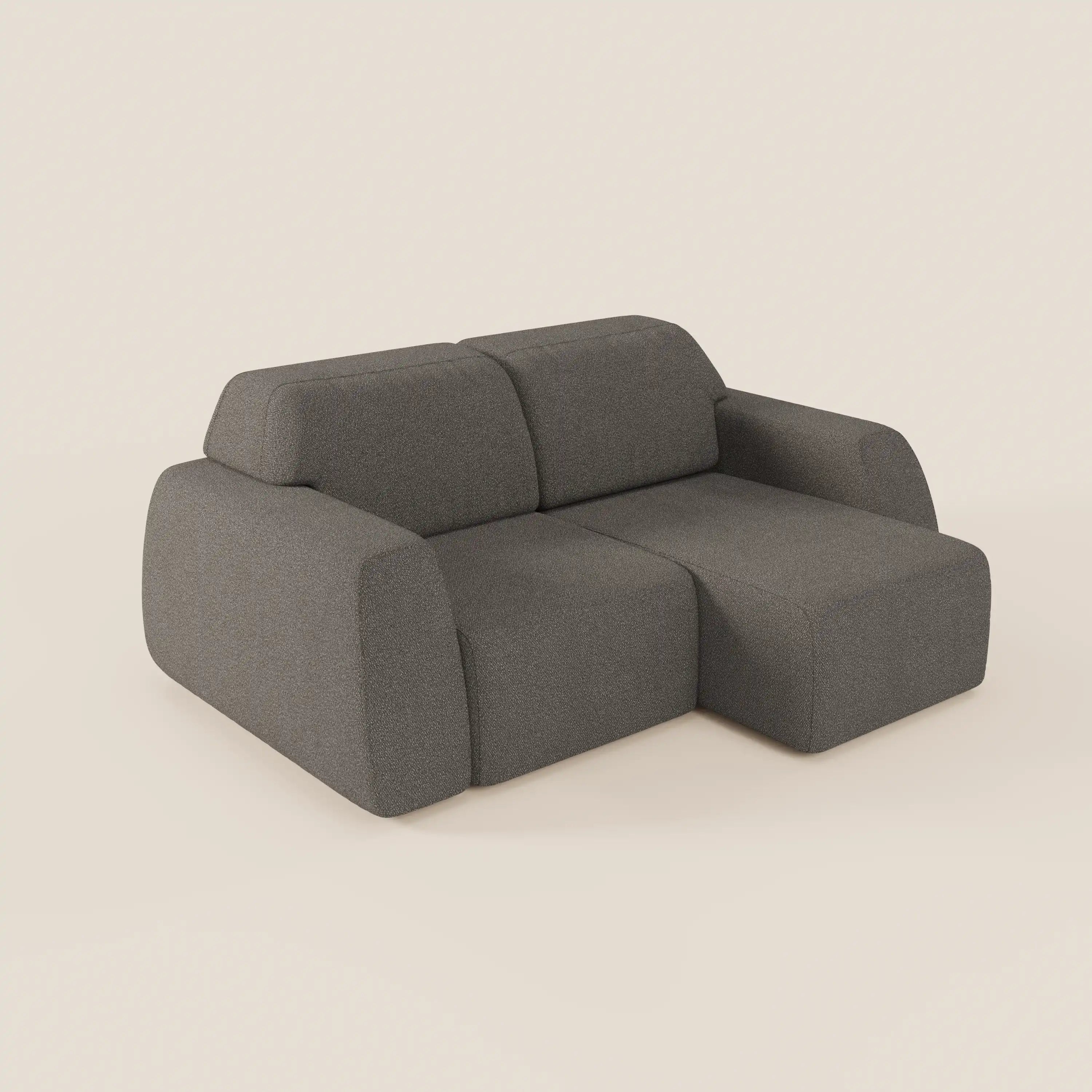 Il divano Orbit 2 e 3 posti di Divani.Store è un divano moderno e minimalista con sedute scorrevoli, braccioli spessi e arrotondati e tessuto smacchiabile effetto cotone T33 grigio scuro. La chaise longue si estende a destra, su sfondo beige chiaro.