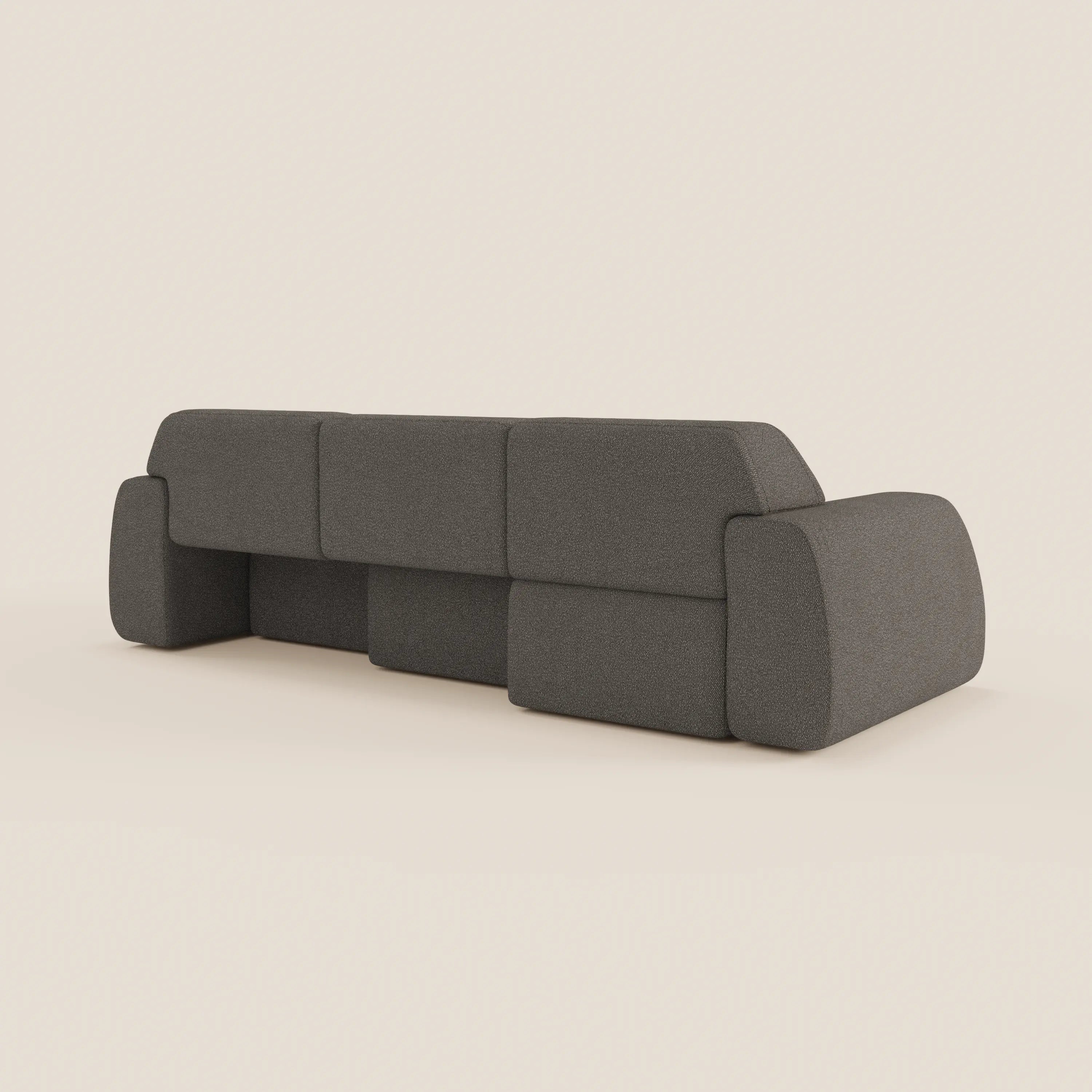 Il divano angolare Orbit con penisola reversibile di Divani.Store, in tessuto smacchiabile effetto cotone T33, è mostrato dal retro su sfondo bianco sporco: profilo basso, ampi braccioli e cuscini rettangolari dal design geometrico essenziale.
