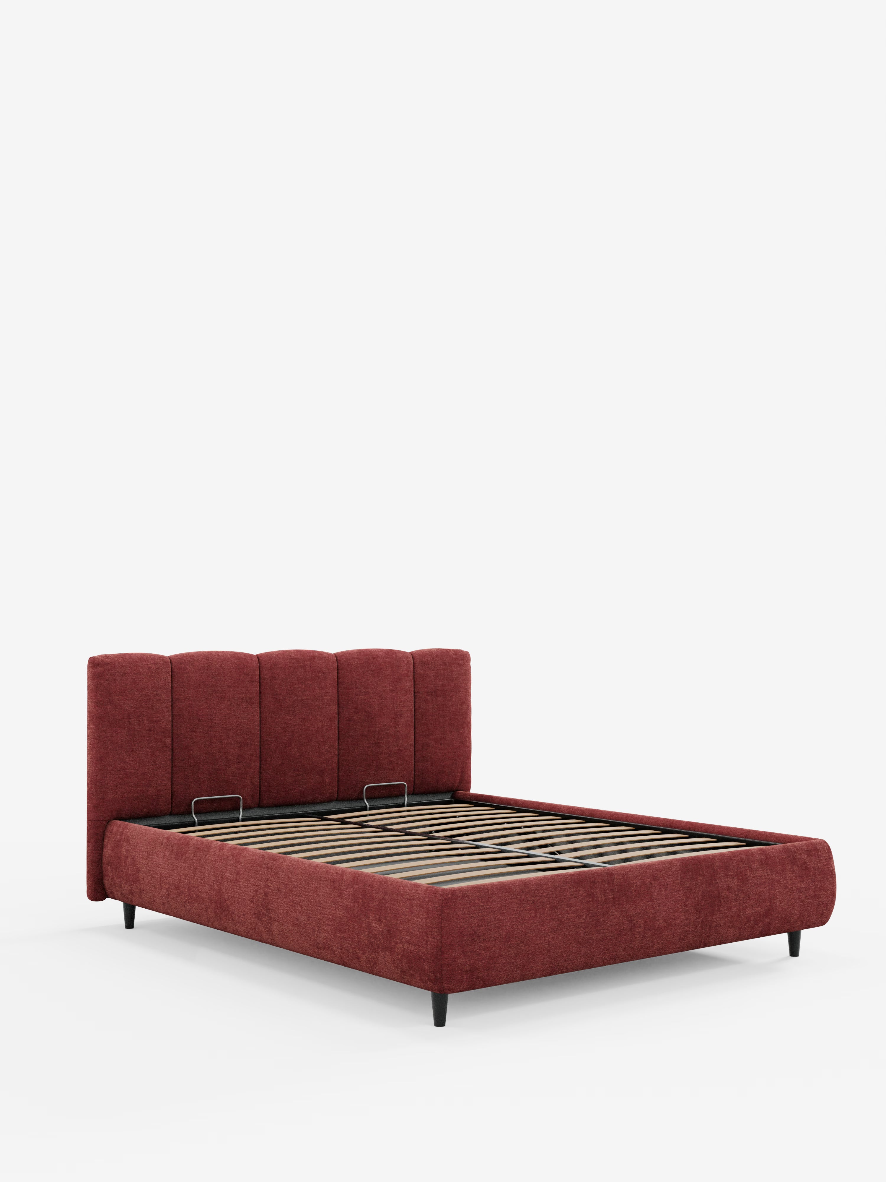 Un moderno letto imbottito ARKAM di Letti.store, caratterizzato da una testiera imbottita con cuciture verticali (testiera a lavorazione verticale) in tessuto rosso intenso certificato Oeko-Tex®, con doghe di sostegno in legno, gambe corte nere e un pratico vano contenitore, presentato su sfondo bianco senza materasso.