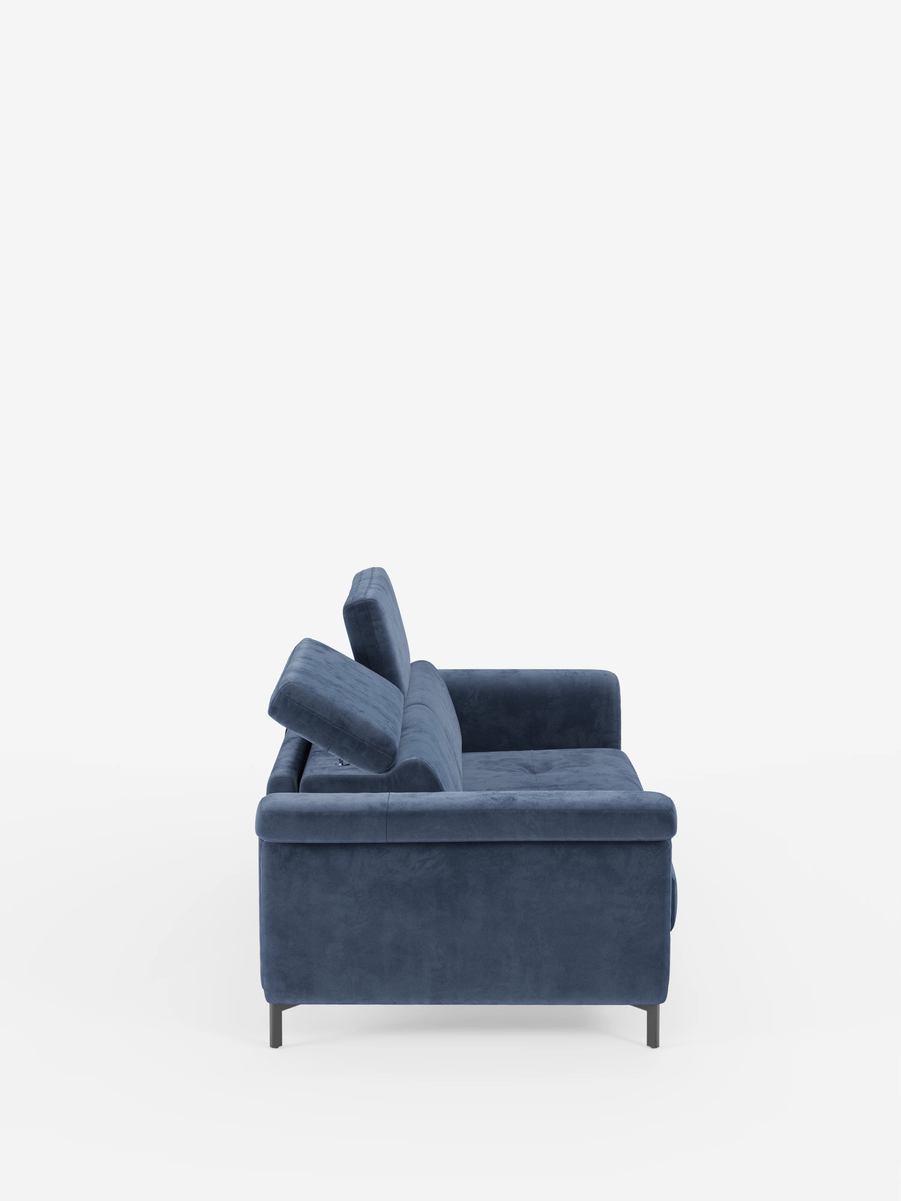 Una vista laterale mette in risalto il divano letto di design Capri con piedini alti di Divani.Store, rivestito in elegante tessuto T30 effetto velluto di colore blu, facile da pulire. Il divano presenta morbidi cuscini dello schienale e della seduta, un unico bracciolo a vista e gambe alte nere che ne sottolineano la silhouette moderna su uno sfondo bianco a tinta unita. I poggiatesta reclinabili e l’eccellenza della produzione italiana ne esaltano sia lo stile che il comfort.