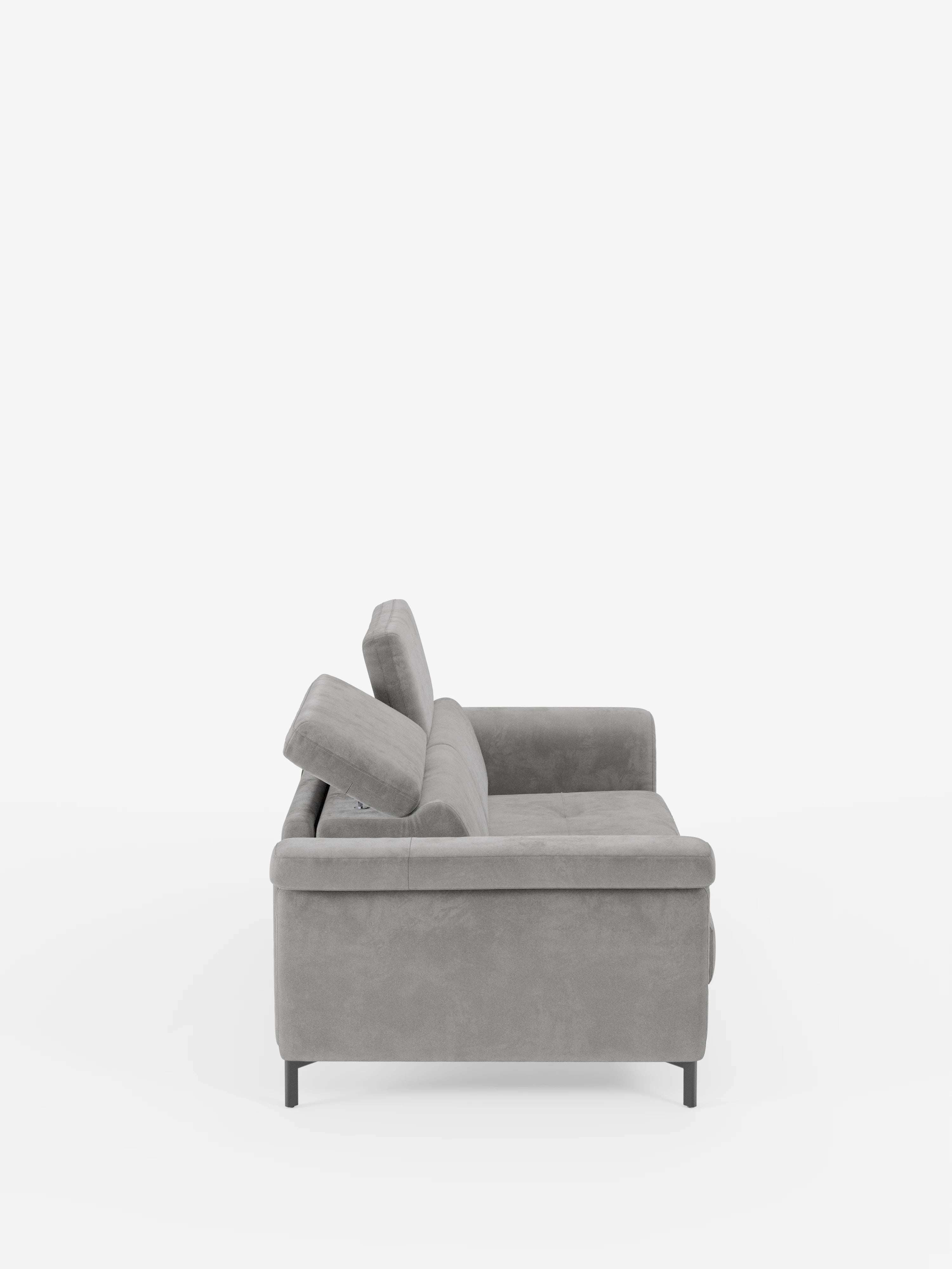 Vista laterale del divano letto di design Capri di Divani.Store, caratterizzato da un raffinato tessuto T30 effetto velluto grigio antimacchia, sottili gambe alte in metallo nero, schienali angolati con poggiatesta reclinabili, una seduta morbida e braccioli dritti, il tutto su uno sfondo bianco a tinta unita.