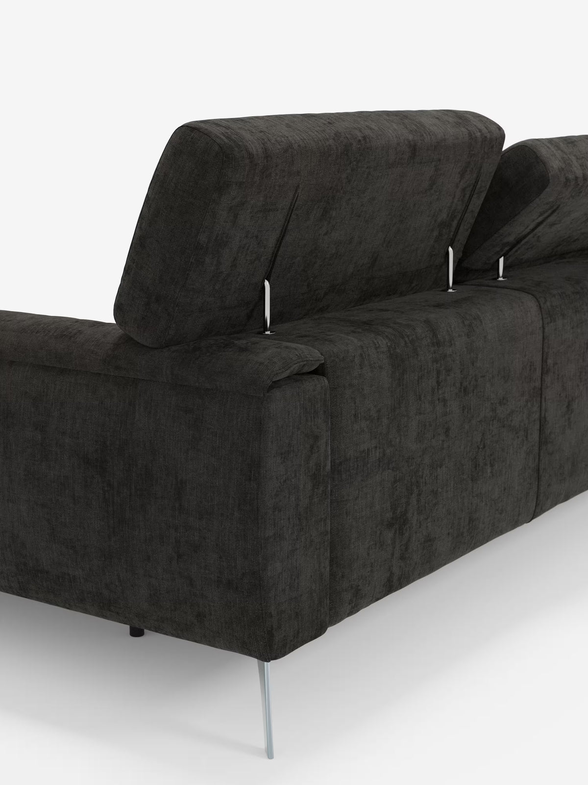 Un primo piano del divano angolare Caravaggio con penisola e sedute scorrevoli in tessuto smacchiabile T31 di Divani.Store, caratterizzato da un design moderno in grigio scuro con poggiatesta regolabili, schienale inclinato e gambe sottili in metallo. Il tessuto ha un aspetto morbido e strutturato e lo stile complessivo è minimalista. Lo sfondo è bianco a tinta unita.