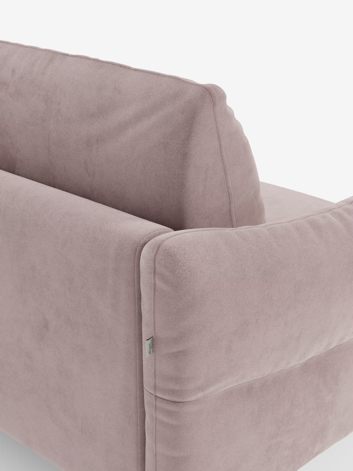 Primo piano del divano letto Dalia a 2, 3 e 4 posti con materasso H18 di Divani.Store, caratterizzato da un rivestimento in morbido tessuto vellutino smacchiabile T30 color malva chiaro. L'immagine mette in risalto lo schienale e il lato del divano, rivestiti con un tessuto morbido simile alla pelle scamosciata, con cuciture precise e ben visibili lungo i bordi e una piccola etichetta in tessuto sul lato. Perfetto come divano letto matrimoniale per il vostro soggiorno, questo modello unisce un comfort