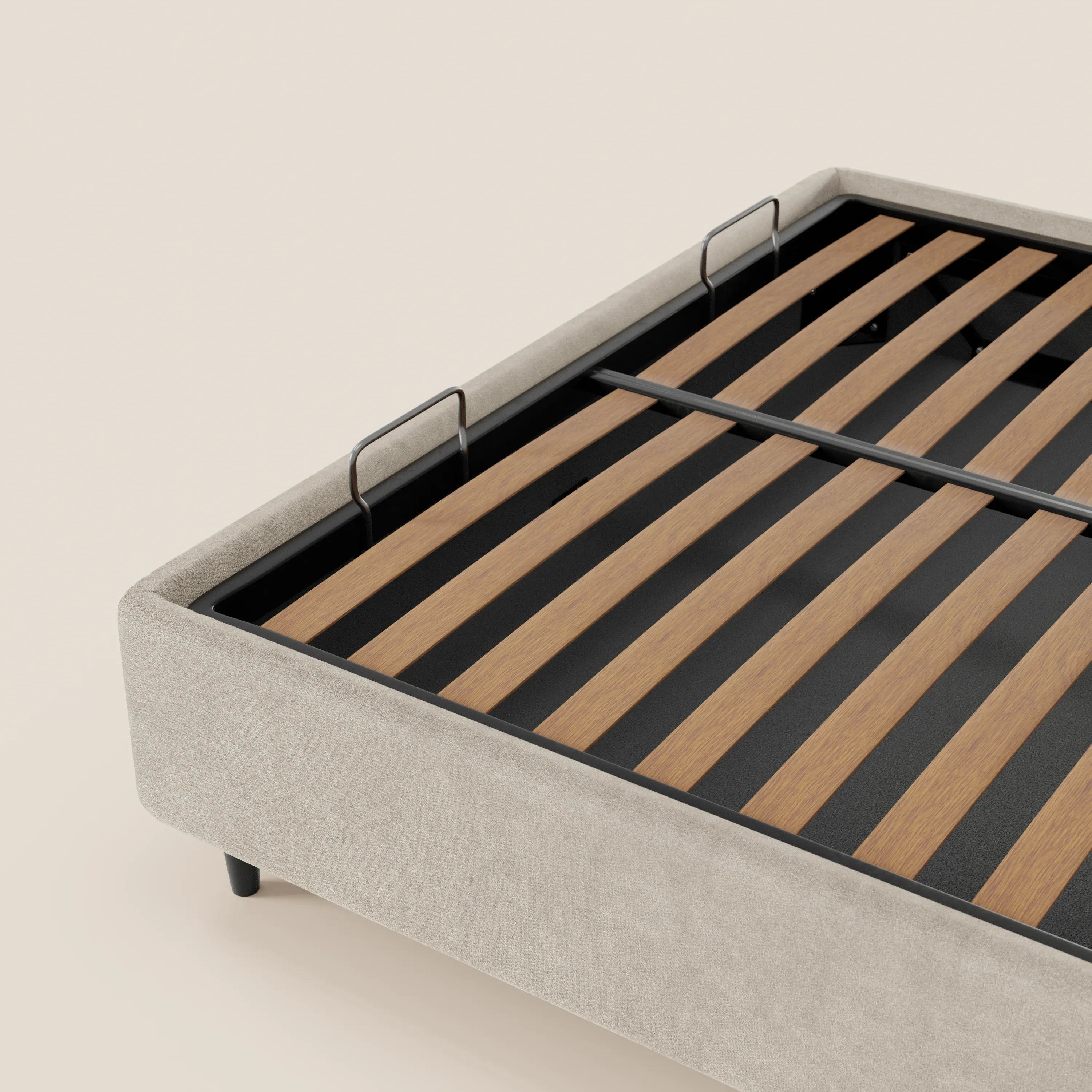 Un primo piano del letto sommier imbottito con contenitore ERON di Letti.store mette in risalto il suo tessuto impermeabile Oeko-Tex color beige chiaro, i supporti in metallo nero e le doghe in legno con due staffe verticali, il tutto su uno sfondo morbido color avorio.
