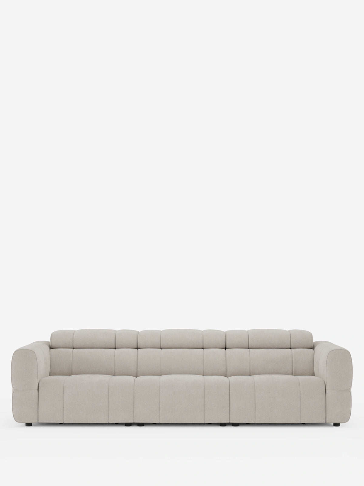 Un ampio divano modulare Giotto a quattro posti con poggiatesta reclinabili e funzione relax elettrica opzionale, rivestito in tessuto smacchiabile T23 color beige chiaro, caratterizzato da un design trapuntato a pannelli, braccioli bassi e uno stile contemporaneo.