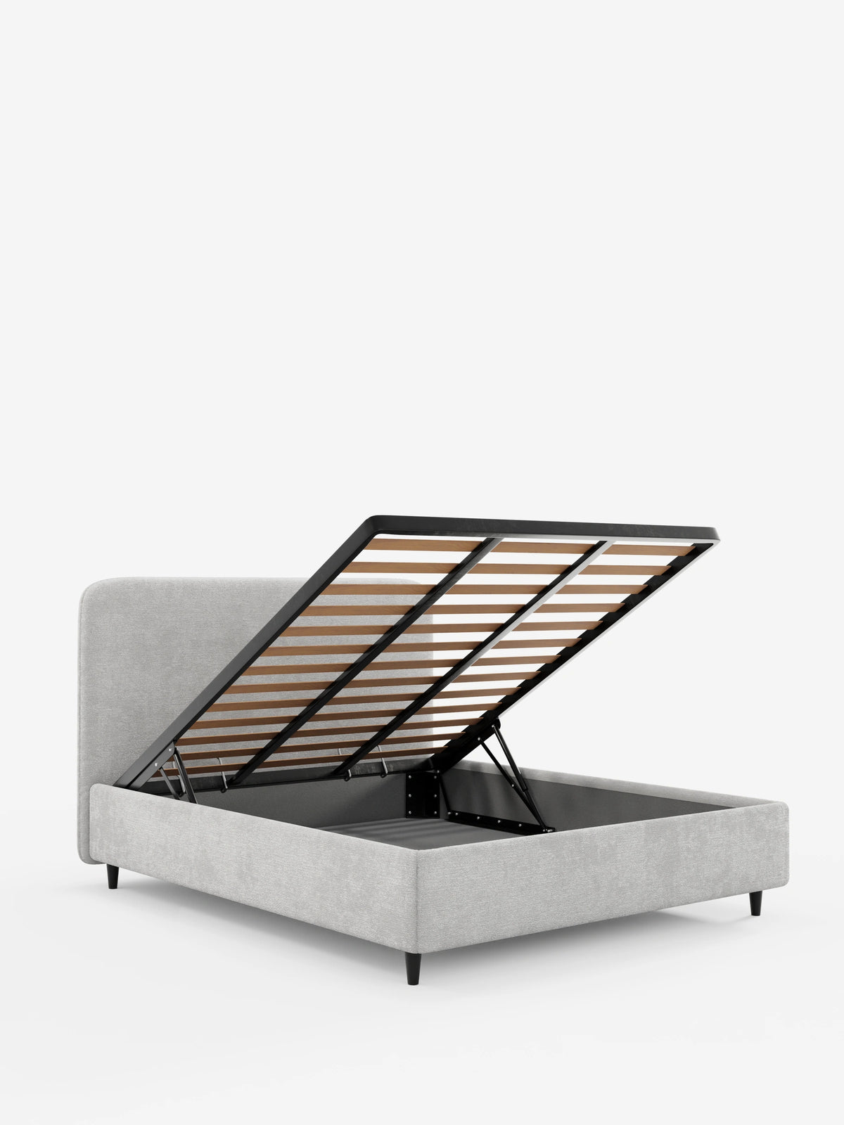 Un letto KAELOS minimal imbottito, di colore grigio chiaro, con testiera arrotondata, lasciata aperta per rivelare il vano contenitore, sostenuto da sottili gambe affusolate di colore scuro e da una base in doghe di legno.