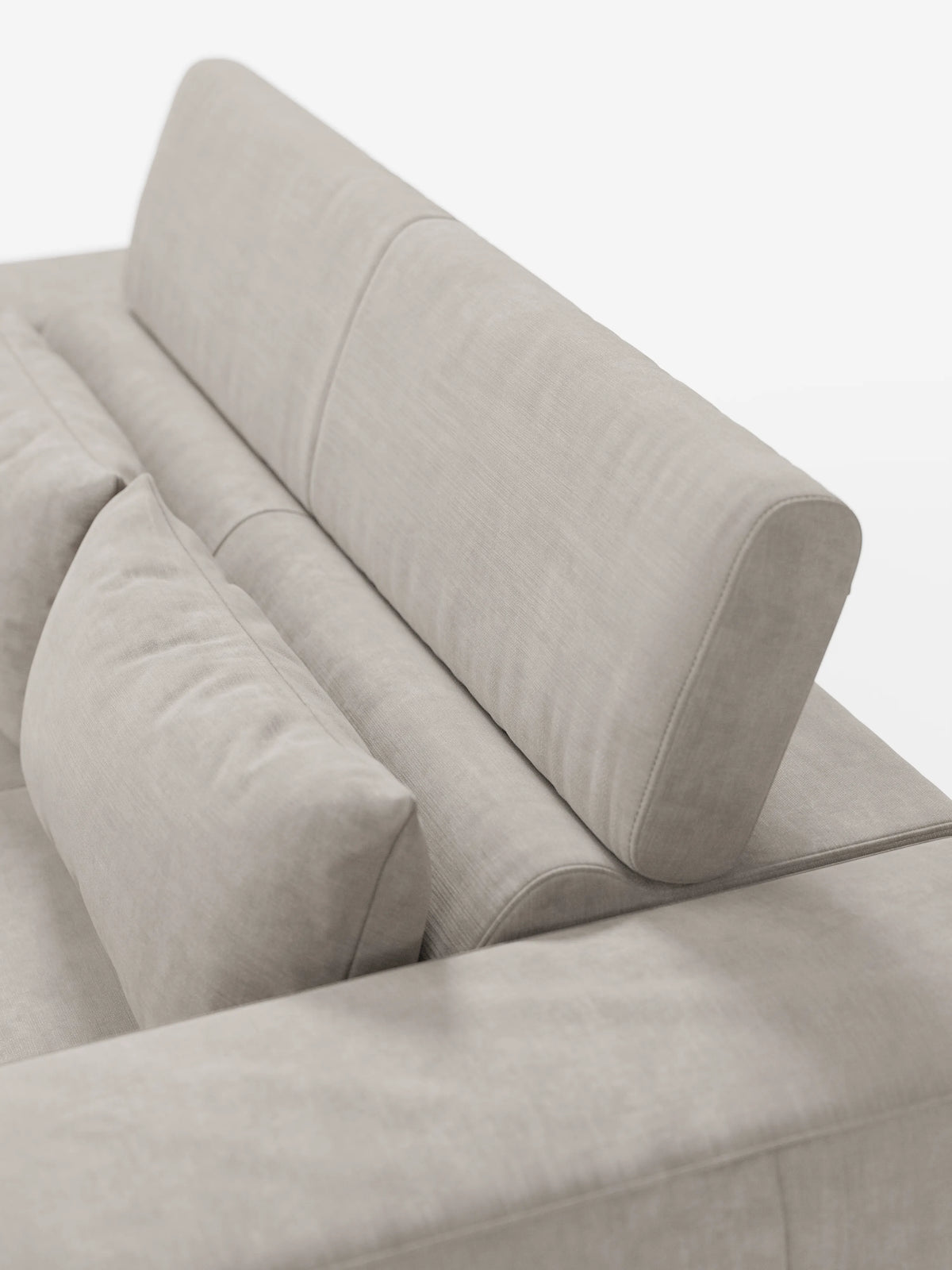 Primo piano del divano Monarch con funzione relax elettrica per l’allungamento delle sedute e poggiatesta reclinabile in morbido tessuto smacchiabile T31 di Divani.Store, che mette in risalto il poggiatesta regolabile, lo schienale avvolgente e il cuscino coordinato. Le linee pulite e il morbido tessuto beige ne sottolineano l’estetica minimalista e contemporanea sullo sfondo bianco.