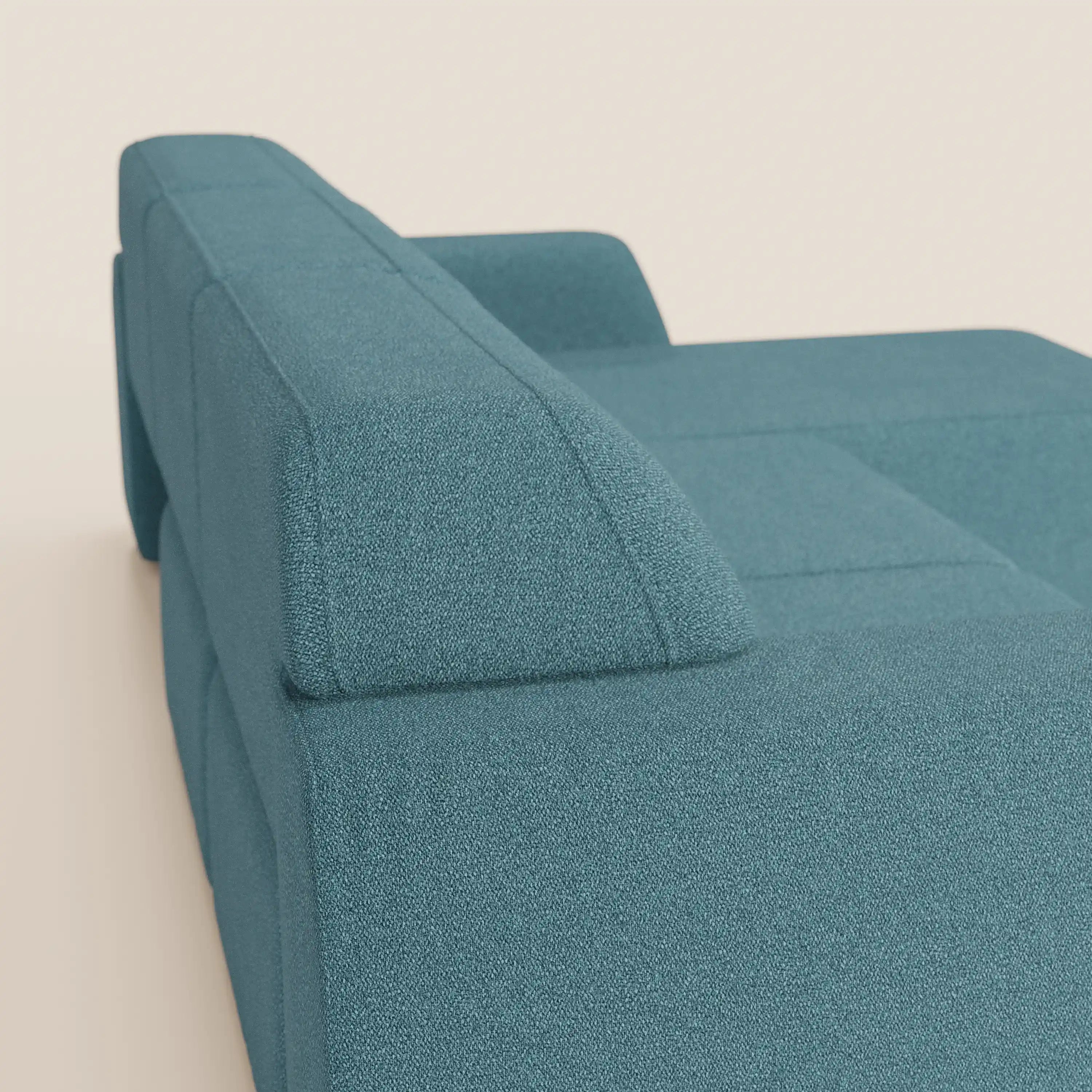 Primo piano di Orbit Divano angolare con penisola reversibile e tutte le sedute allungabili di Divani.Store in tessuto smacchiabile effetto cotone T33, con bracciolo e schienale moderni che si stagliano su uno sfondo beige chiaro per un look raffinato e minimalista.