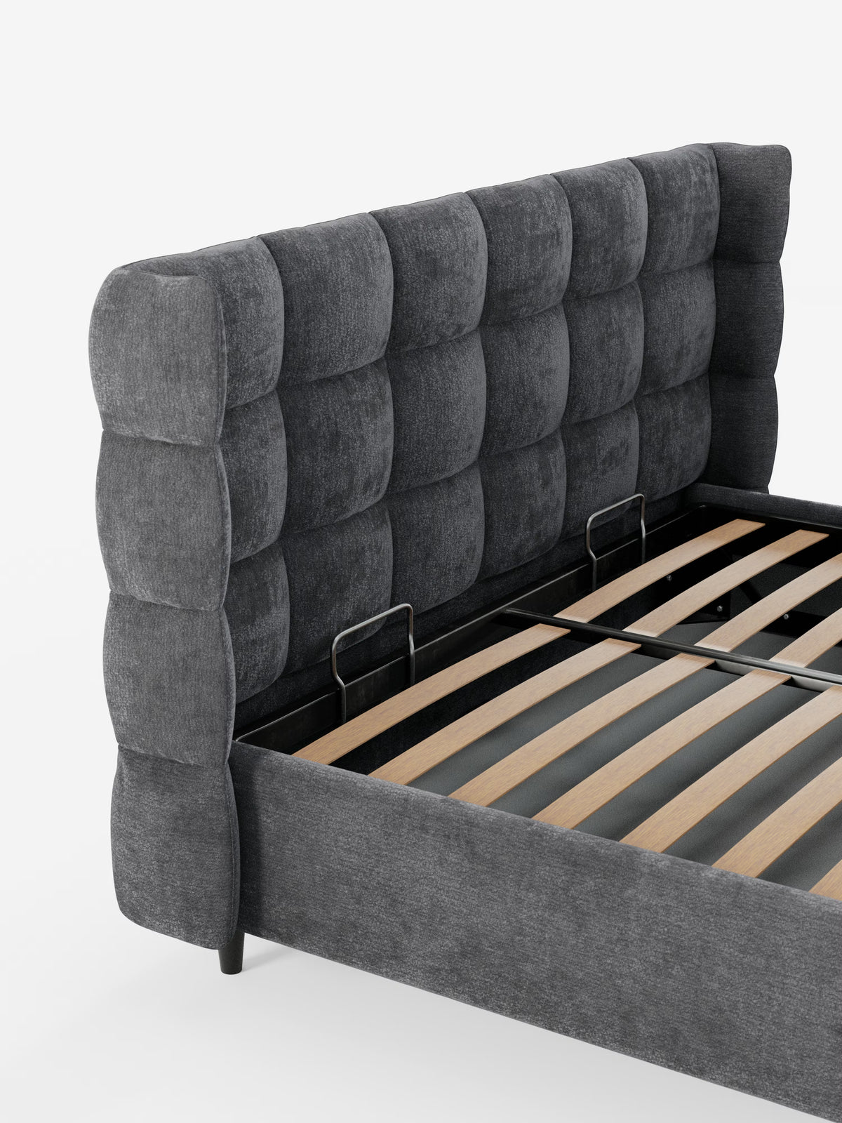 Un primo piano del letto imbottito RAGNAR con contenitore e testiera capitonné avvolgente di Letti.store, caratterizzato da un’alta testiera imbottita di colore grigio scuro con motivo a griglia, realizzata in elegante tessuto certificato Oeko-Tex®. All’interno del telaio del letto sono visibili i supporti a doghe in legno e due barre di sostegno centrali in metallo.