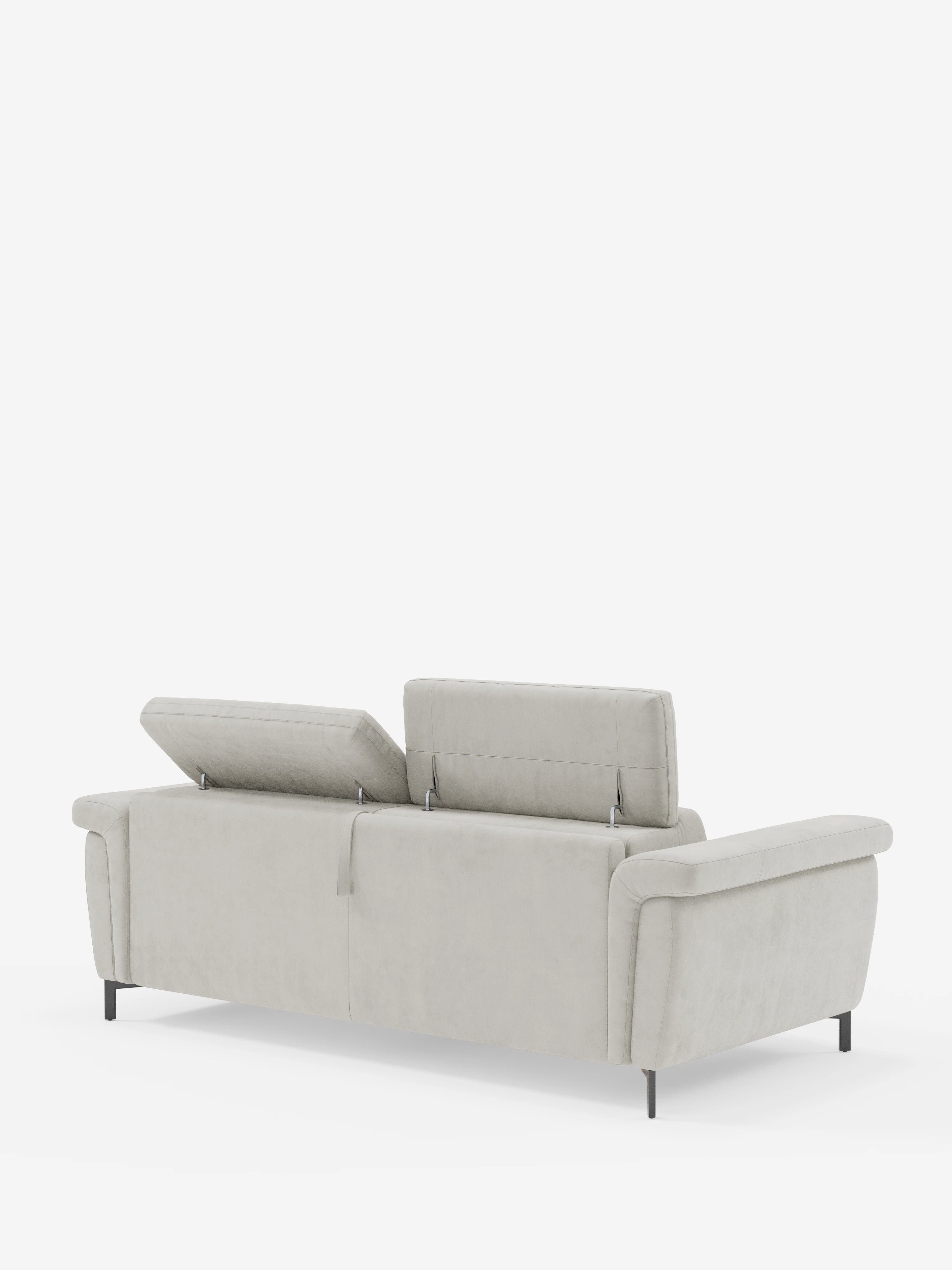 Il divano letto di design Capri con piedini alti di Divani.Store è presentato nella vista posteriore, rivestito in un moderno tessuto T30 grigio chiaro effetto velluto, resistente alle macchie. È dotato di tre poggiatesta regolabili — due in posizione verticale e uno parzialmente reclinabile — e poggia su gambe nere eleganti e slanciate. Questo divano minimalista incarna la raffinata manifattura italiana, fondendo perfettamente stile e funzionalità su uno sfondo bianco a tinta unita.
