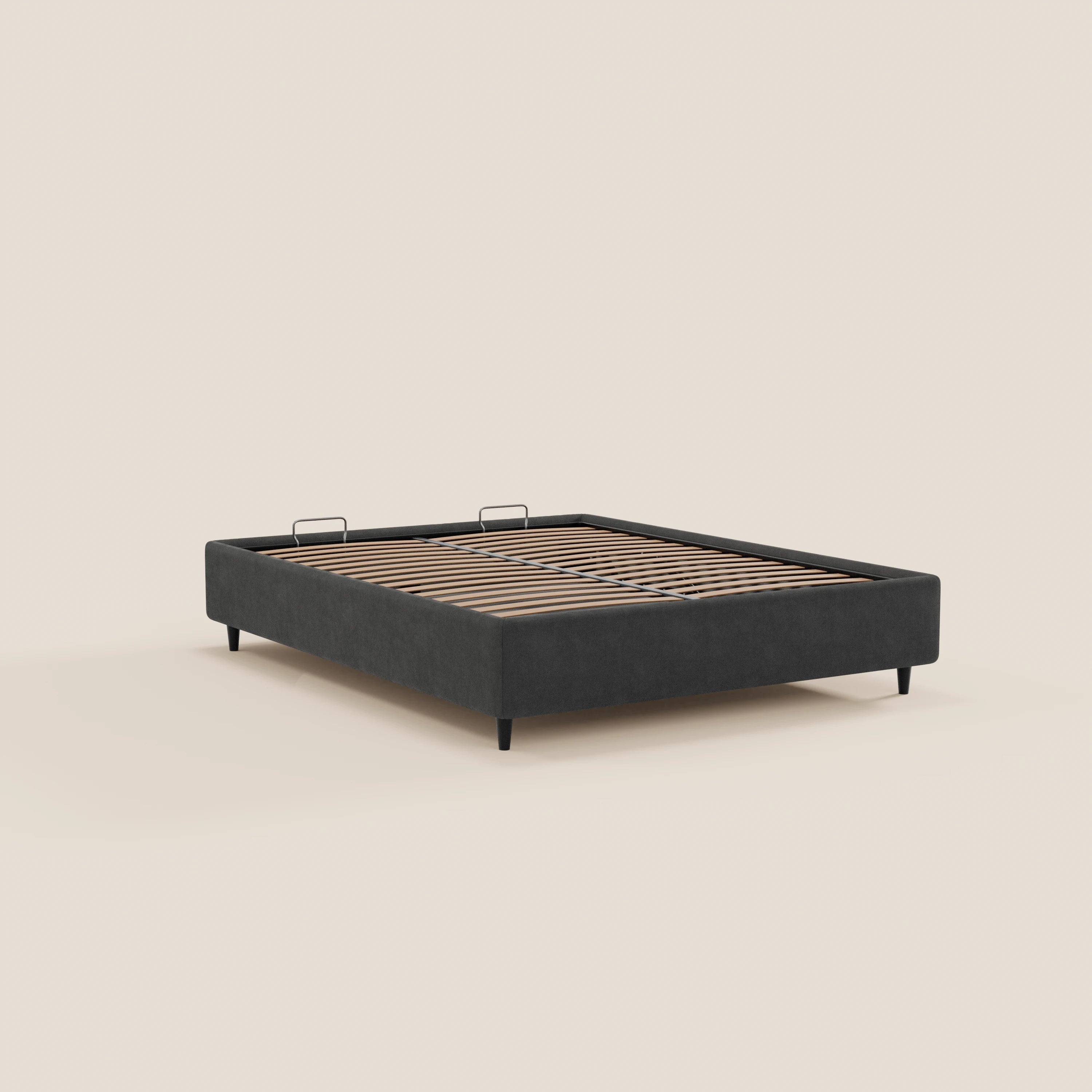 Il letto sommier ERON di Letti.store è un letto imbottito, realizzato in tessuto impermeabile certificato Oeko-Tex e dotato di vano contenitore. Si caratterizza per un profilo minimalista e ribassato e poggia su gambe sottili e inclinate, che risaltano su uno sfondo beige a tinta unita.