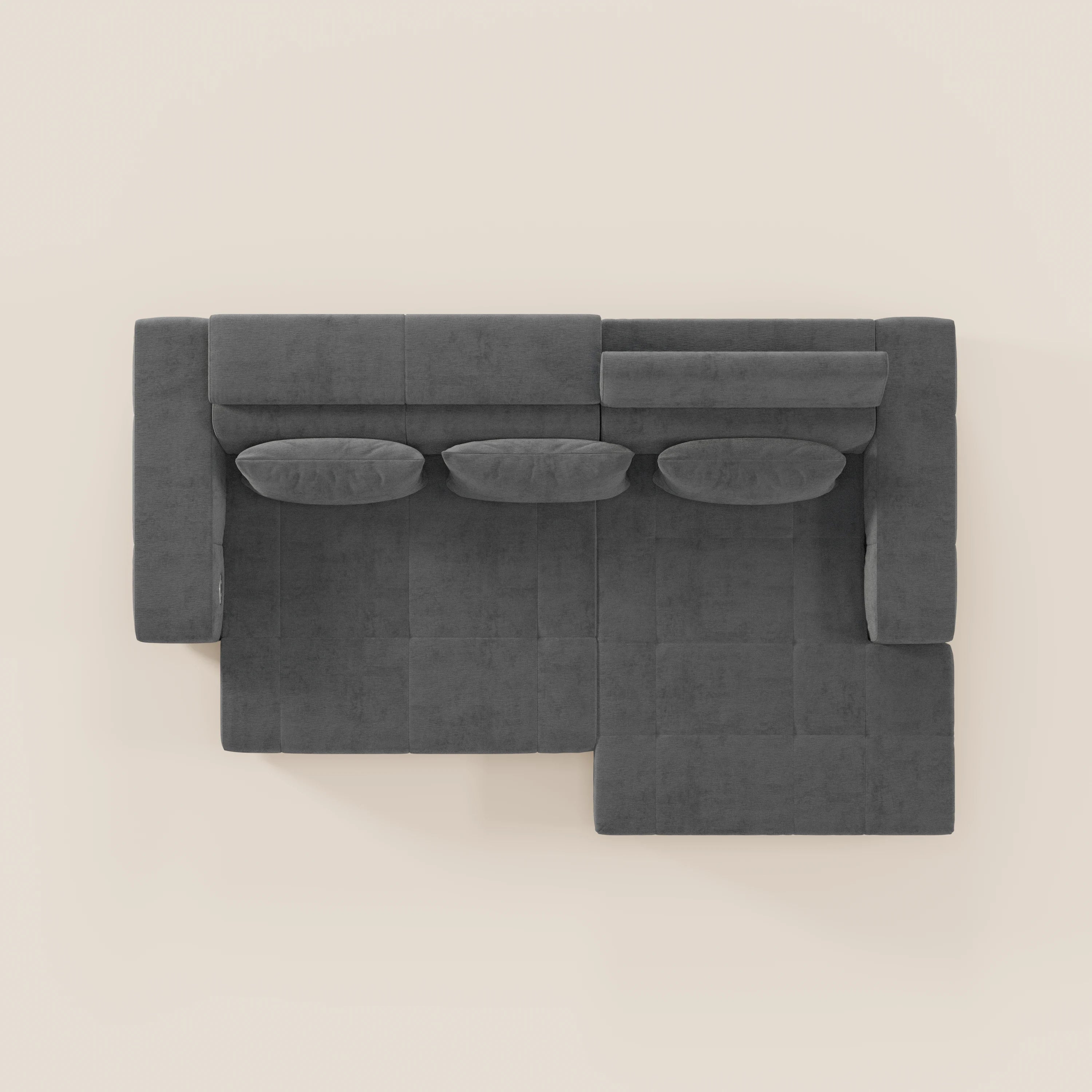 Vista dall'alto del Monarch Divano angolare con penisola e Relax Elettrico di Divani.Store, caratterizzato da tre cuscini per seduta e schienale, tre cuscini cilindrici e un design moderno e minimalista in grigio scuro su sfondo beige chiaro.