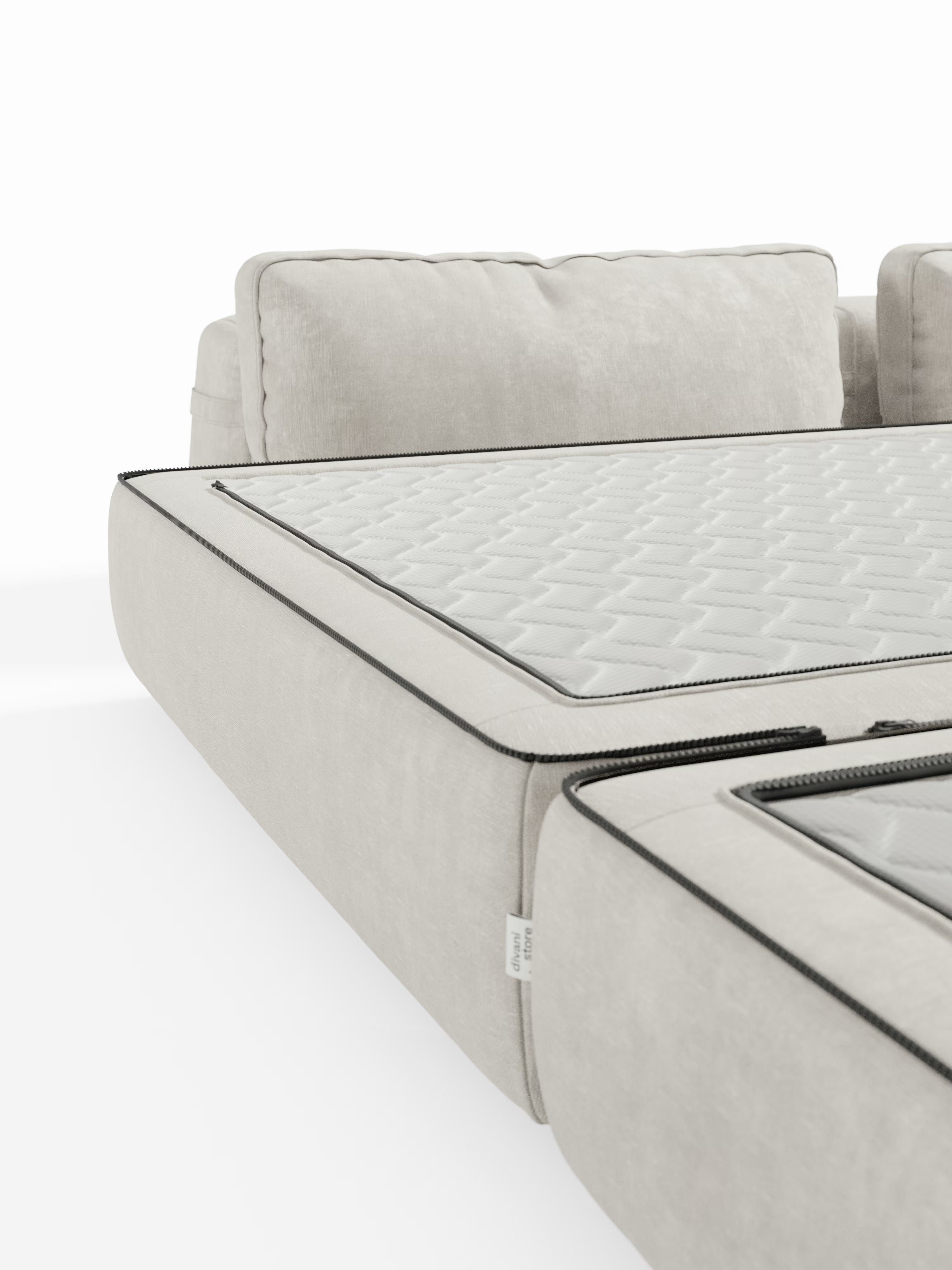 Un primo piano del divano letto matrimoniale Rift a 2 e 3 posti con schienali mobili di Divani.Store, qui presentato in un rivestimento moderno color beige chiaro. L'immagine mette in risalto un pannello imbottito trapuntato con cerniera, parzialmente aperto per rivelare l'imbottitura interna. Il divano presenta morbidi cuscini dello schienale e una bordatura nera a contrasto lungo i bordi. Si trasforma facilmente in un letto spazioso con un comodo materasso in memory foam T31 alto 22 cm all'interno.