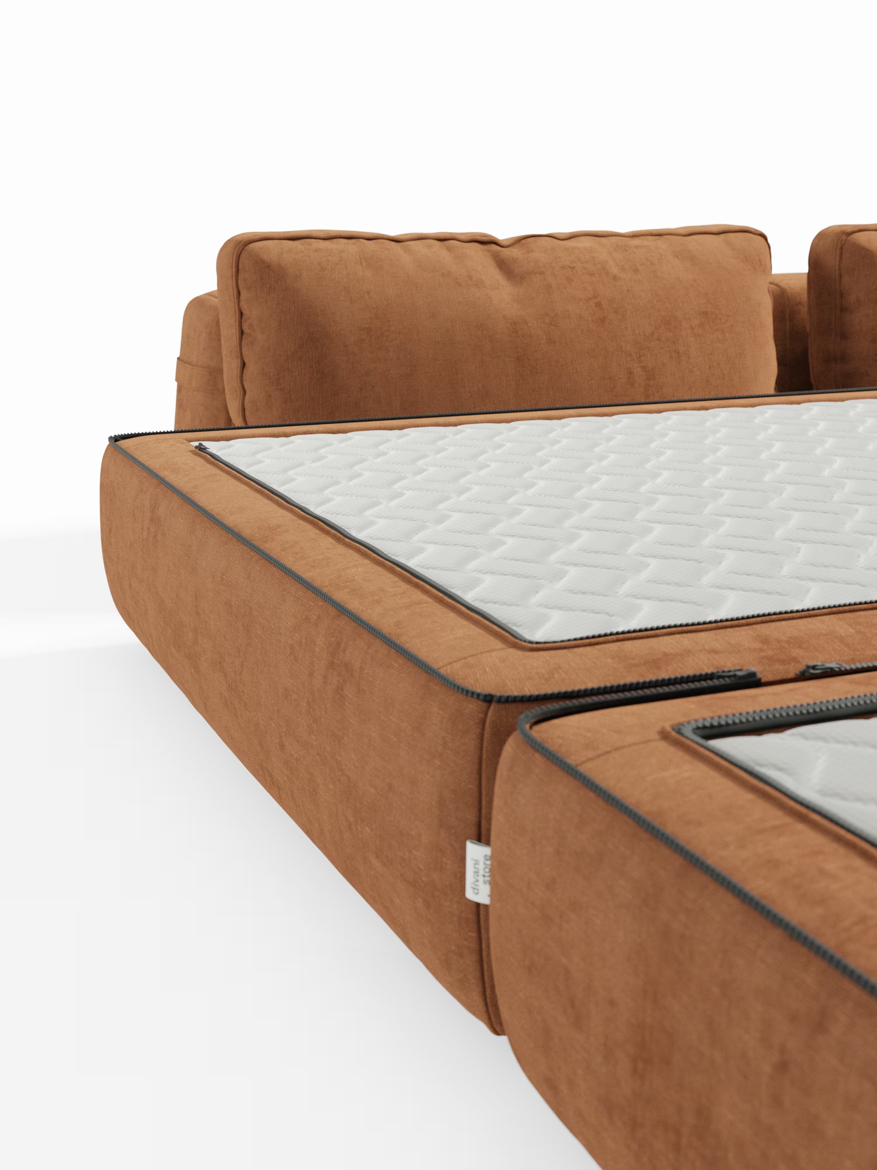 Primo piano del divano letto matrimoniale Rift di Divani.Store, qui presentato con rivestimento in tessuto color ruggine. I cuscini della seduta si aprono tramite una cerniera per rivelare il materasso in memory foam T31 alto 22 cm, rivestito internamente da una fodera trapuntata bianca. Uno sfondo bianco a tinta unita mette in risalto la texture moderna del divano e i dettagli costruttivi, tra cui i caratteristici schienali mobili.