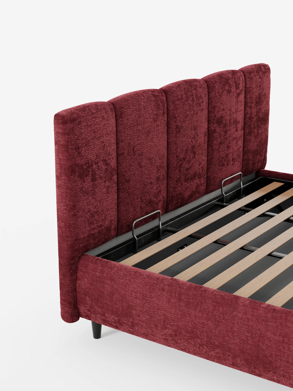 Un letto imbottito ARKAM di colore rosso intenso con contenitore e testiera a lavorazione verticale su sfondo bianco, che mostra una testiera a pannelli verticali e una base aperta con doghe in legno e due fermi metallici per il materasso.