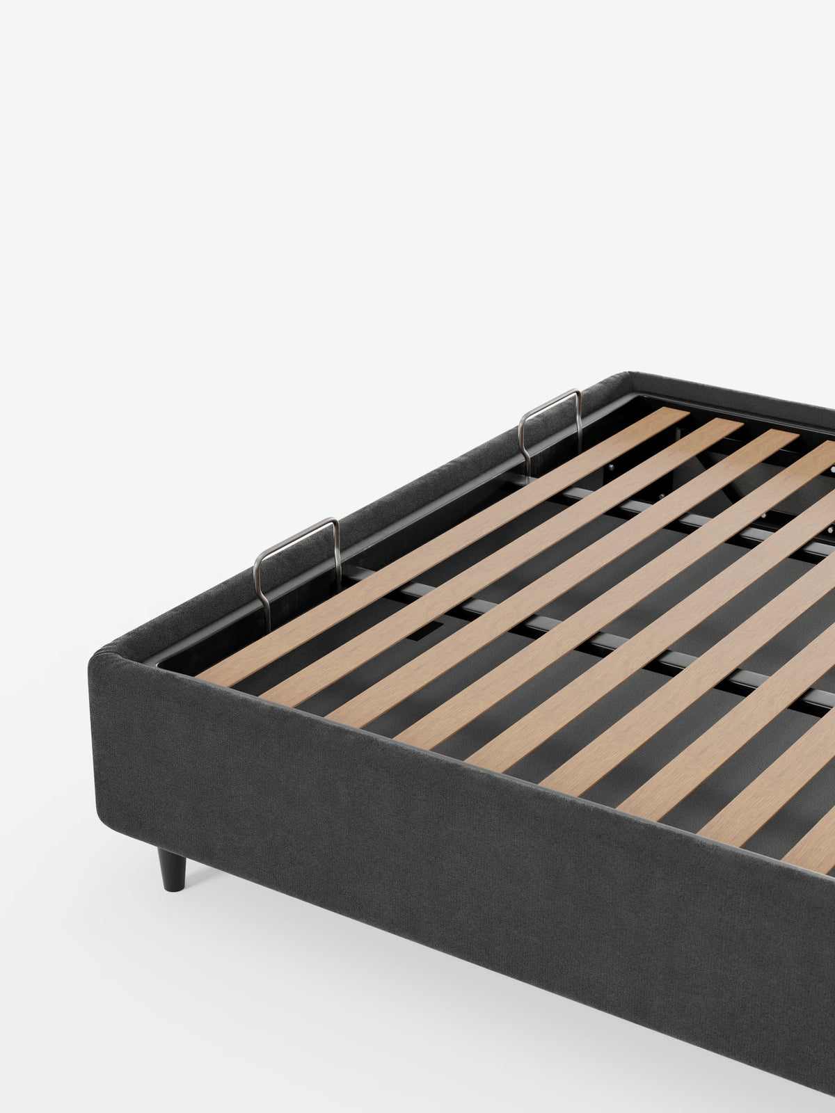 Letto sommier ERON color antracite scuro, imbottito, con vano contenitore in tessuto impermeabile certificato Oeko-Tex, dotato di base a doghe in legno e due staffe metalliche fissate al telaio interno, su uno sfondo bianco a tinta unita.
