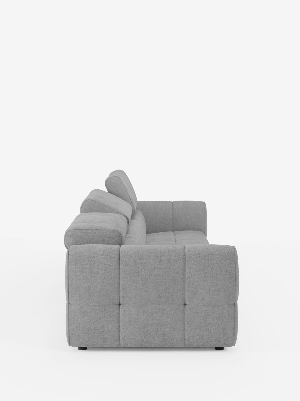Vista laterale di un divano modulare Giotto grigio chiaro a 4 posti con poggiatesta reclinabili e funzione relax elettrica opzionale, rivestito in tessuto smacchiabile T23, caratterizzato da un motivo rettangolare trapuntato, braccioli imbottiti e due poggiatesta regolabili.