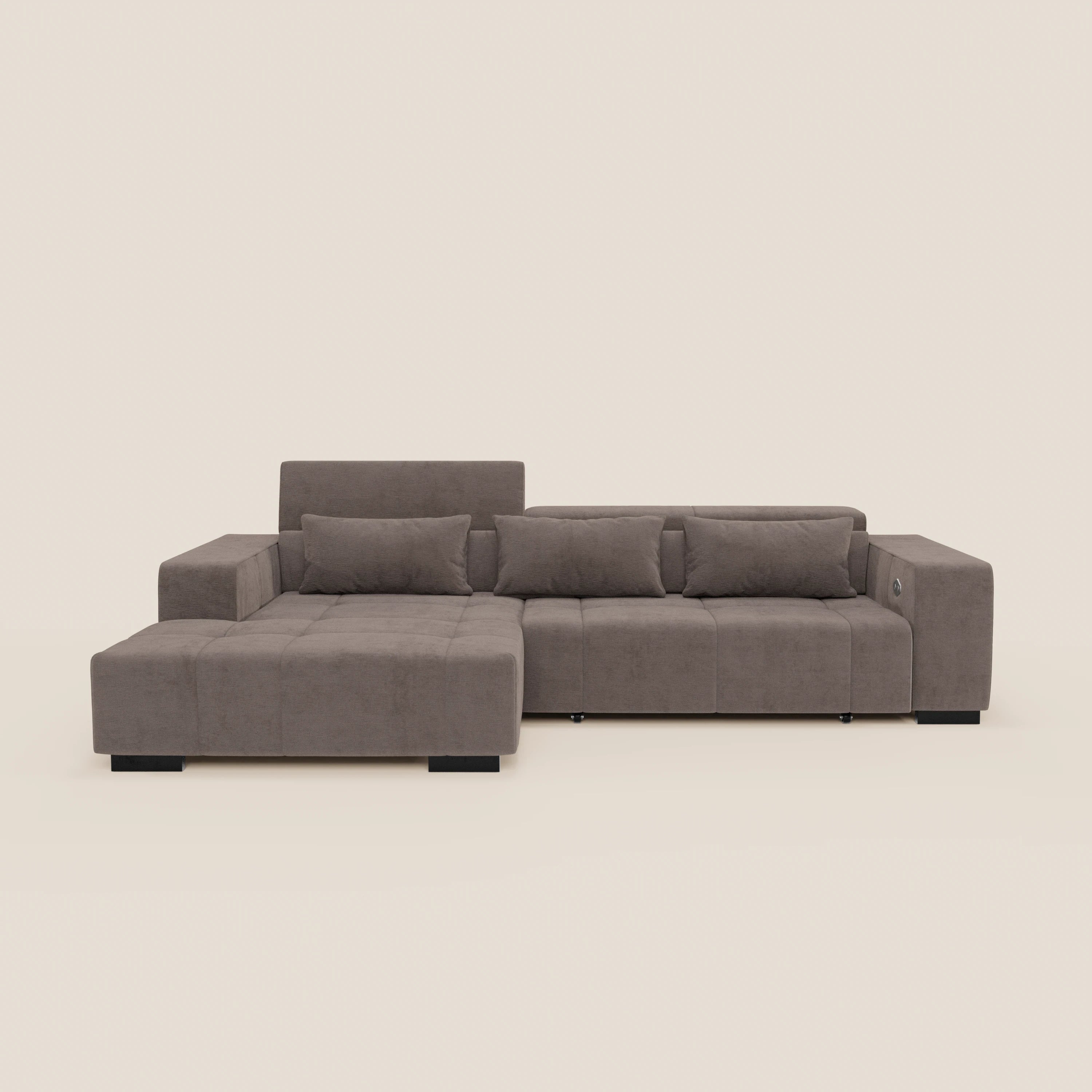 Il Monarch Divano angolare di Divani.Store è dotato di chaise longue, sedile allungabile elettricamente e poggiatesta reclinabili, rivestiti in morbido tessuto antimacchia T31; in figura tre cuscini su sfondo beige chiaro.