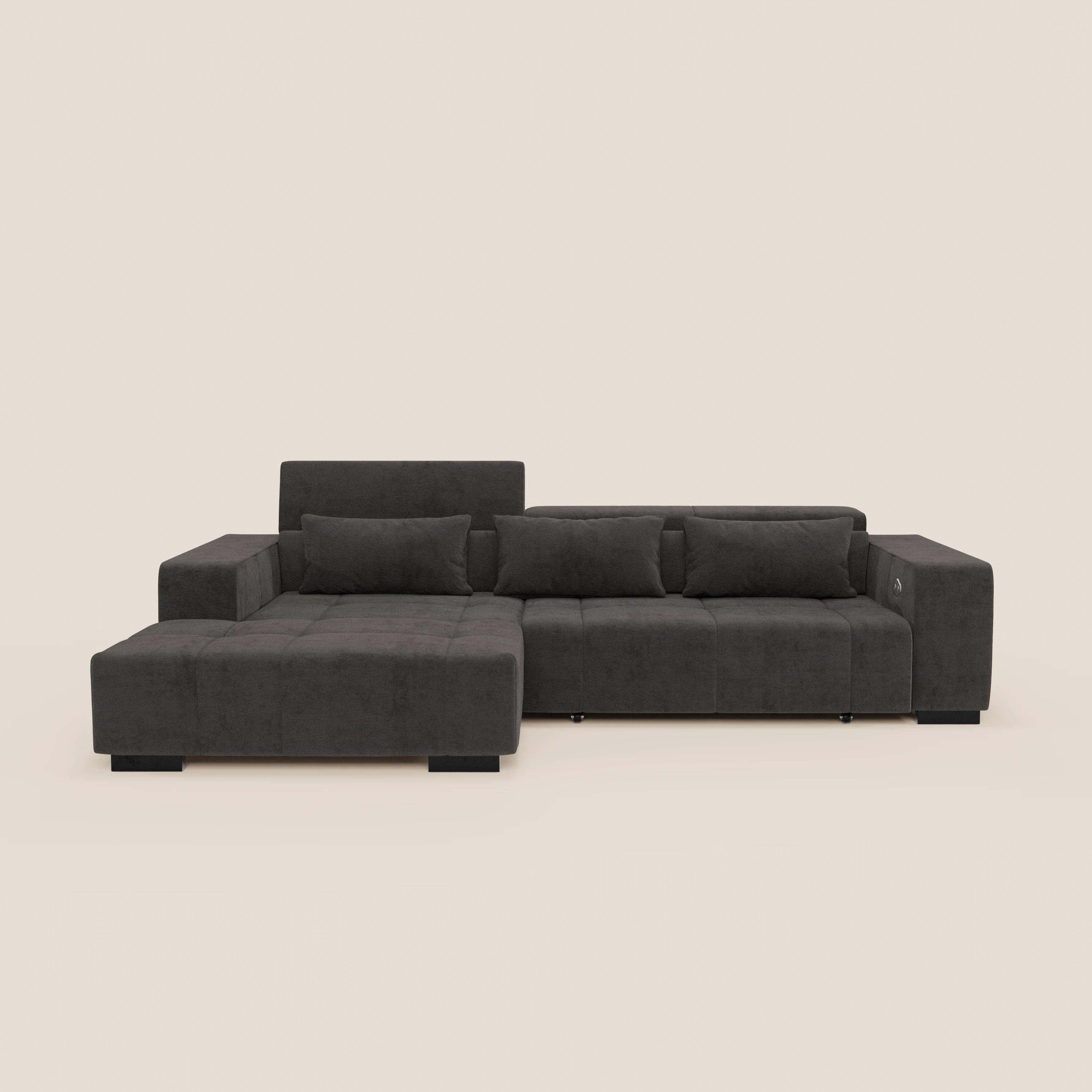 Il divano angolare Monarch di Divani.Store è caratterizzato da chaise longue sinistra, tripla seduta destra, ampi braccioli, poggiatesta reclinabili, allungamento elettrico della seduta e cuscini a blocco in tessuto smacchiabile T31 grigio scuro su gambe corte nere.