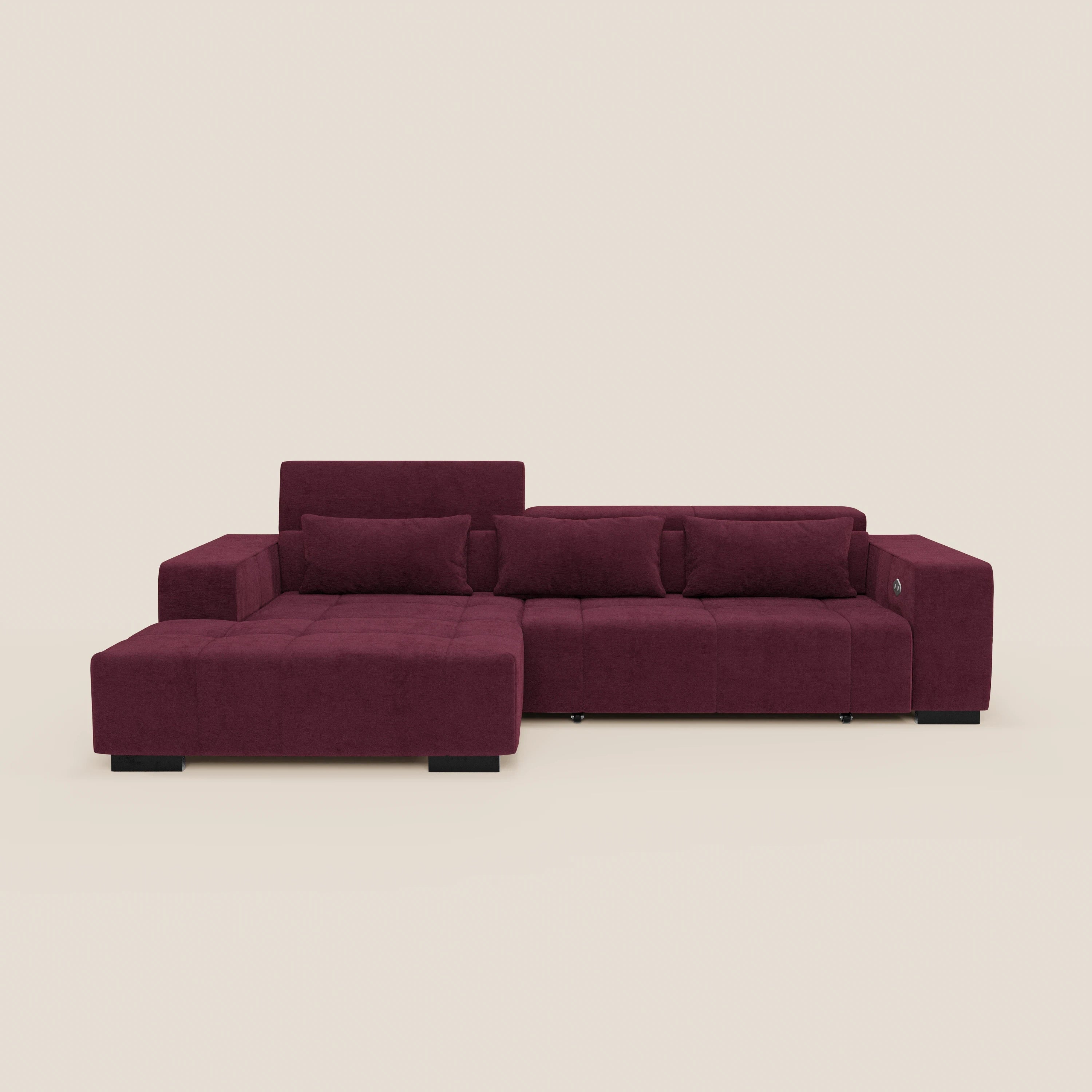 Il Monarch Divano angolare con penisola e Relax Elettrico di Divani.Store, in tessuto smacchiabile T31, ha poggiatesta reclinabili, ampi braccioli e chaise lounge a sinistra, con gambe nere e 3 cuscini coordinati su sfondo beige chiaro.
