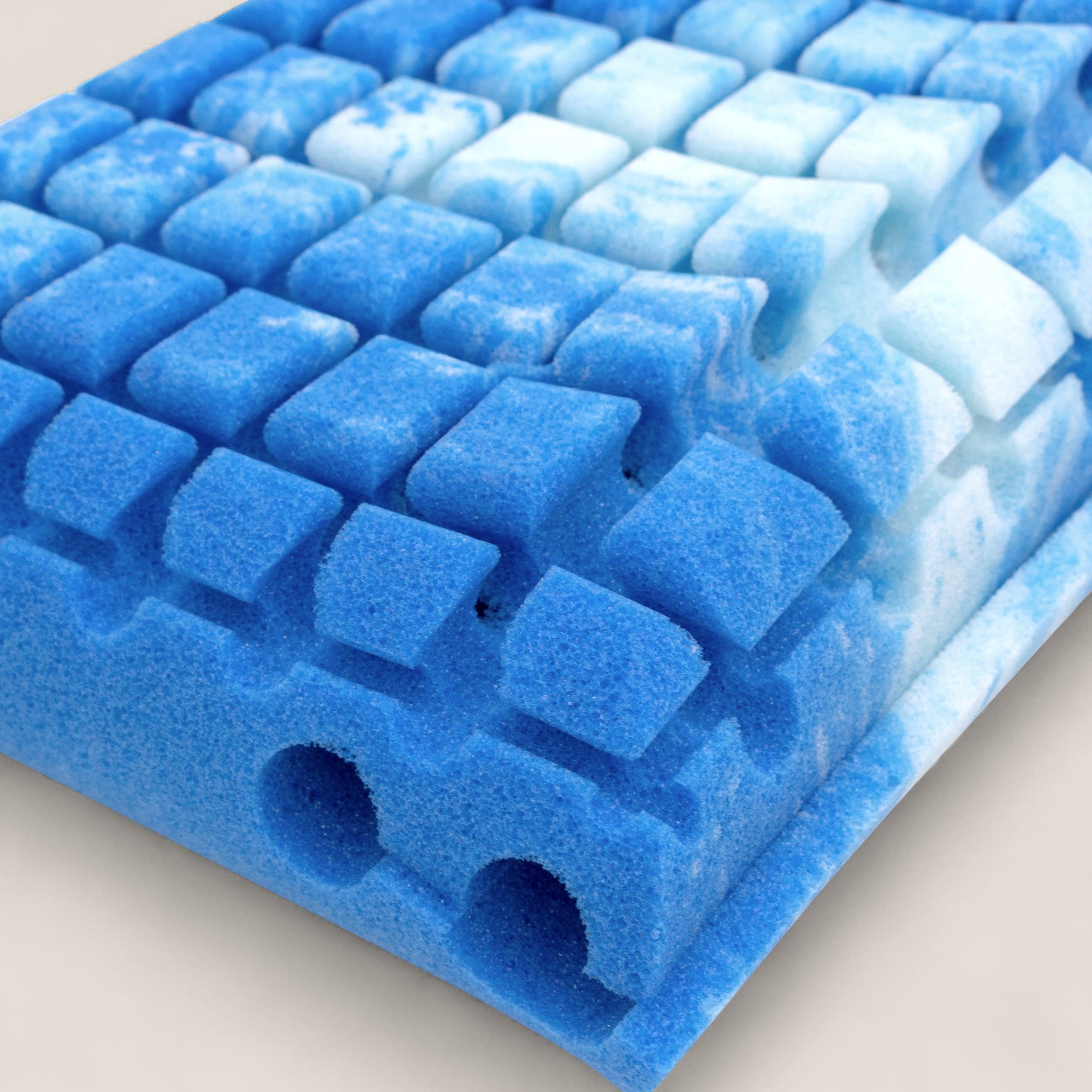 Primo piano del guanciale AERION-BREEZE in Memory Gel di Divani.Store, caratterizzato da una schiuma marmorizzata con una griglia di quadrati arrotondati e due grandi fori per l'aria per un supporto ergonomico e proprietà termoregolanti.