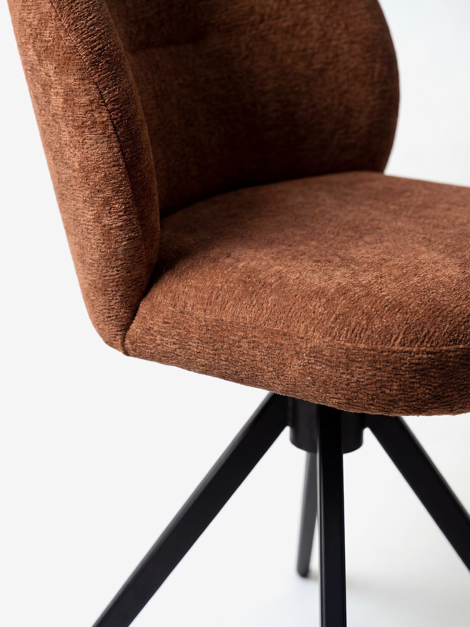 Primo piano della sedia imbottita Alba di Divani.Store, realizzata con tessuto effetto cotone certificato OEKO-TEX® e base in metallo nero. L'immagine mette in risalto il design elegante, il rivestimento testurizzato e lo schienale arrotondato.