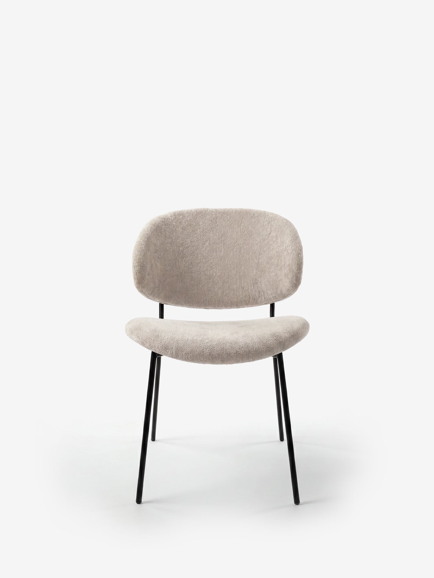 La sedia Bruma di Divani.Store è caratterizzata da un elegante tessuto goffrato in beige chiaro, un design minimalista con schienale avvolgente e seduta confortevole, e gambe sottili in metallo nero. Fotografata su sfondo bianco.
