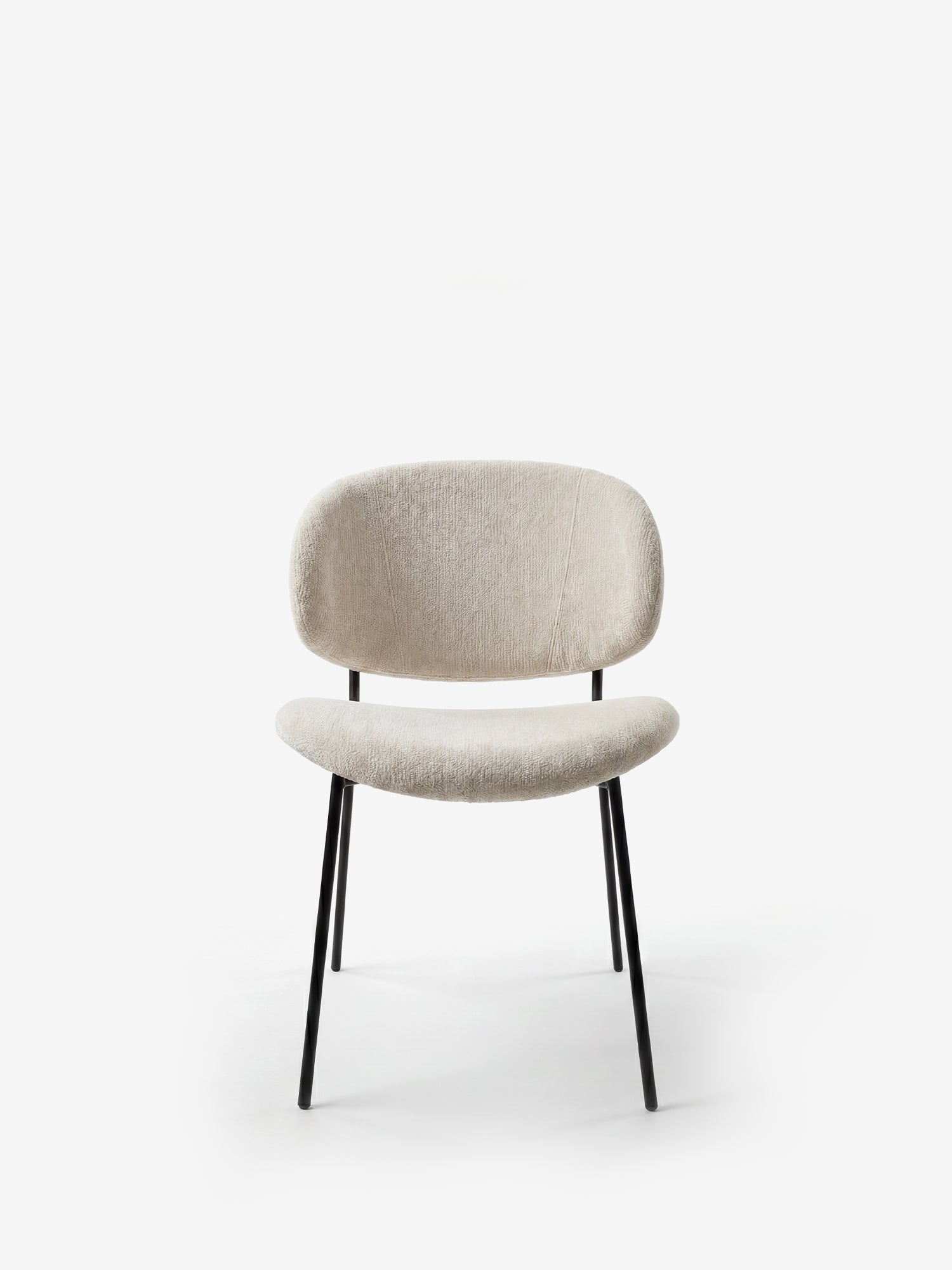 La sedia La Bruma di Divani.Store presenta un design minimalista con schienale avvolgente, rivestimento in elegante tessuto goffrato beige chiaro e gambe in metallo nero inclinate, perfetta per gli ambienti moderni.