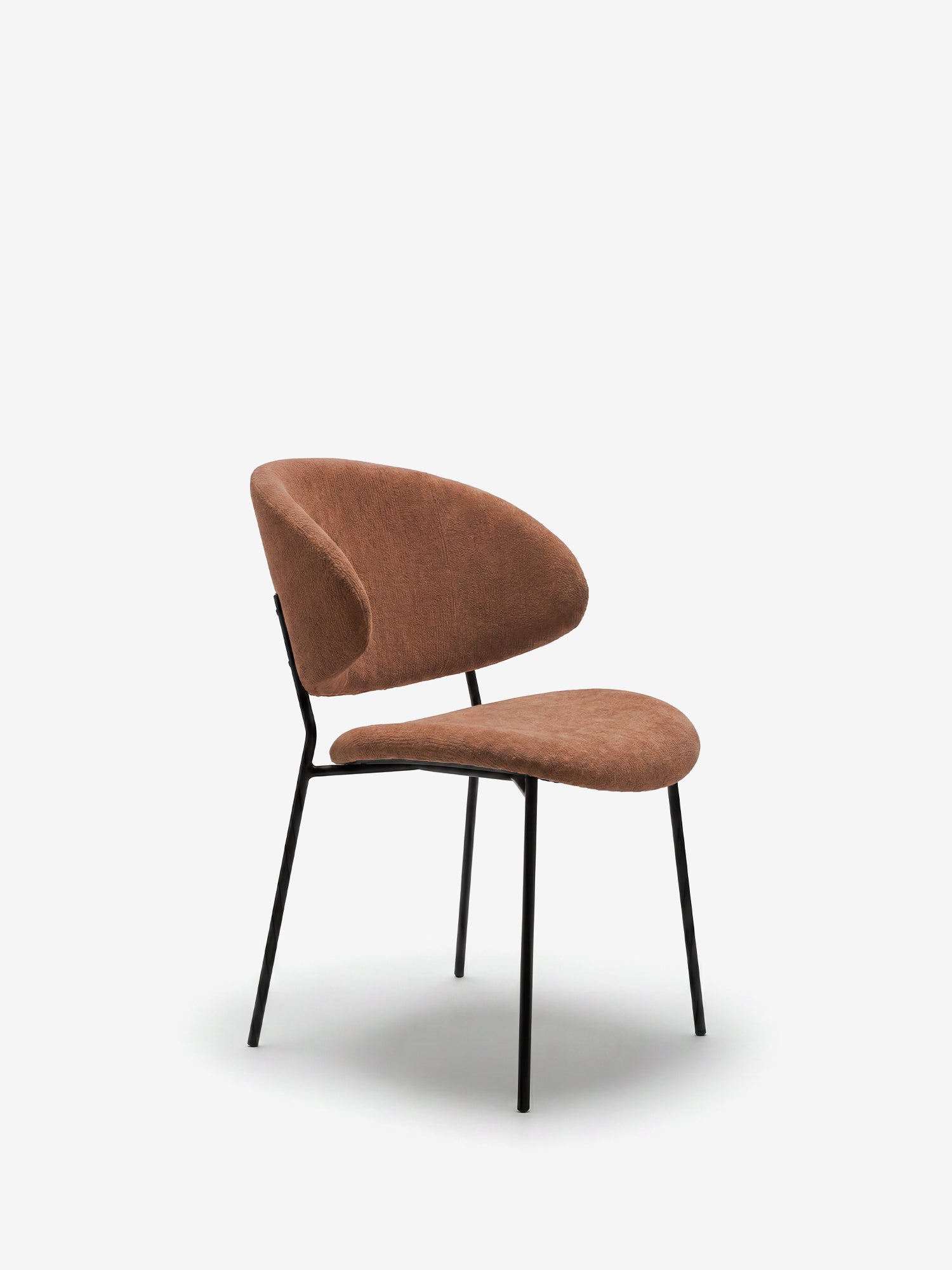 La sedia Bruma di Divani.Store è caratterizzata da un elegante tessuto goffrato, un design minimalista con schienale avvolgente e gambe sottili in metallo nero, perfetta per gli ambienti moderni. Sfondo bianco semplice.