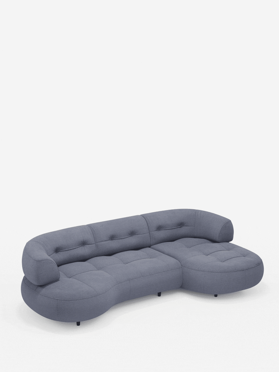 Croissant, divano angolare dal design a forma di fagiolo con schienali scorrevoli in morbido tessuto effetto cotone smacchiabile T33: un divano modulare a forma di fagiolo in blu tenue con sedute trapuntate e schienali arrotondati, poggiato su piedini bassi e scuri su uno sfondo bianco.