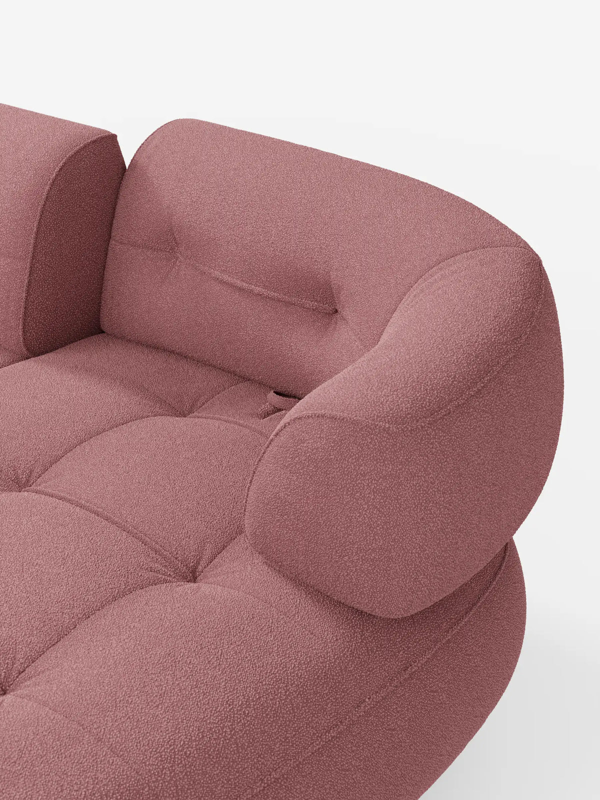 Un primo piano del divano angolare “Croissant” in rosa polveroso, dal design a fagiolo e con schienali scorrevoli, rivestito in morbido tessuto effetto cotone smacchiabile T33, caratterizzato da una superficie curva e testurizzata, braccioli arrotondati e cuscini di seduta trapuntati.