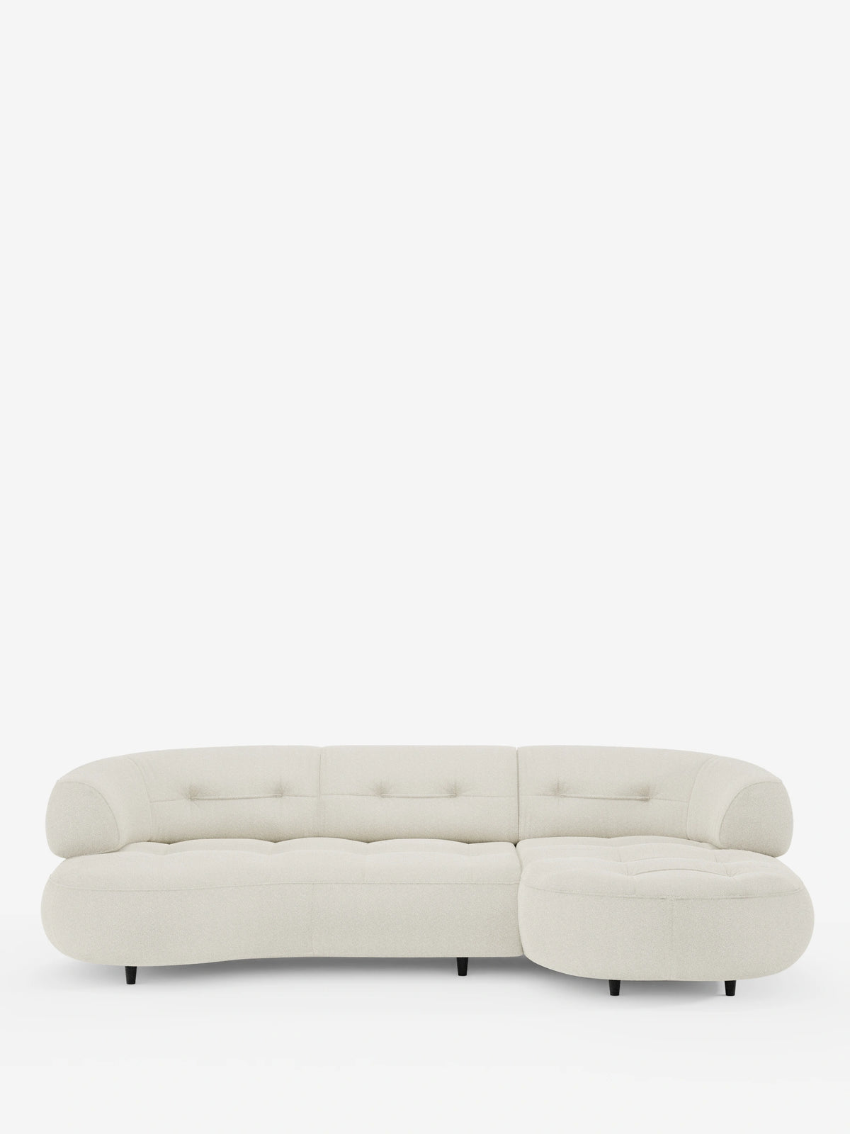 Un divano angolare Croissant dal design a forma di fagiolo e con schienali scorrevoli, rivestito in morbido tessuto effetto cotone smacchiabile T33, caratterizzato da una silhouette curva a forma di fagiolo in tessuto testurizzato color crema, con cuscini trapuntati e piccoli piedini neri.
