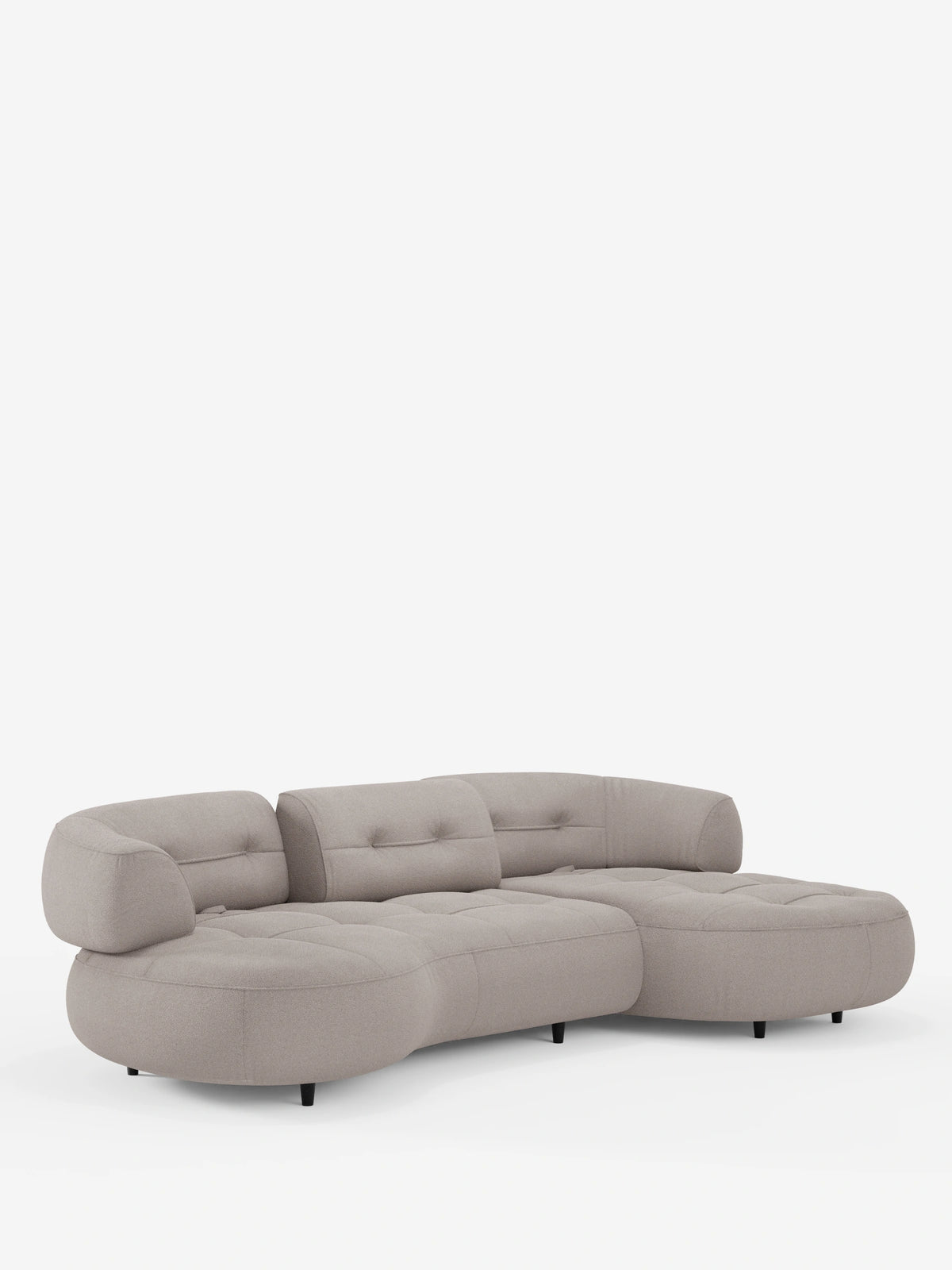 Un divano angolare Croissant dalla forma ricurva a fagiolo, con schienali scorrevoli in morbido tessuto effetto cotone smacchiabile T33 color beige chiaro, si staglia su uno sfondo bianco con seduta trapuntata e gambe nere.