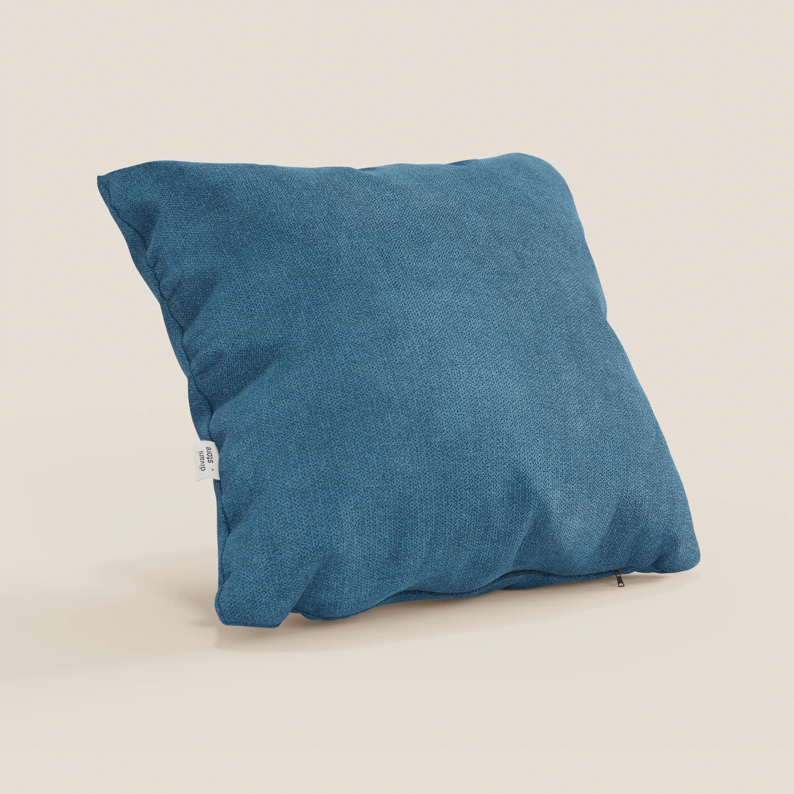 Il cuscino Destiny di Divani.Store, 45x45 cm in morbido tessuto impermeabile T02 azzurro, si erge su uno sfondo beige chiaro. Una piccola etichetta bianca è applicata su un lato e una cerniera parzialmente visibile corre lungo il bordo inferiore.