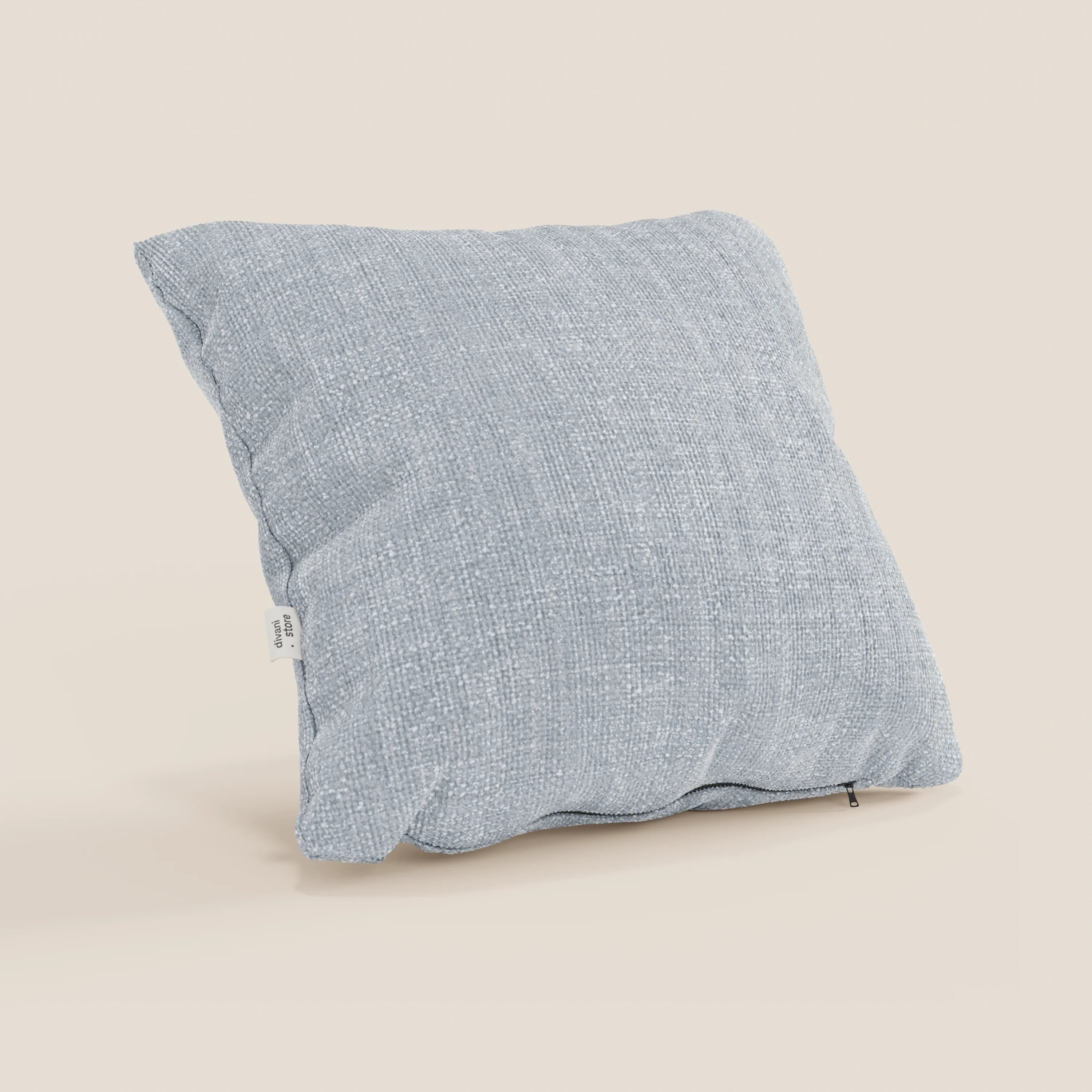 Il cuscino Lyon di Divani.Store in T06 ghiaccio è un cuscino azzurro 45x45 cm in morbido tessuto impermeabile, con etichetta bianca e tirazip a vista. Appare soffice e leggermente imbottito su uno sfondo beige.