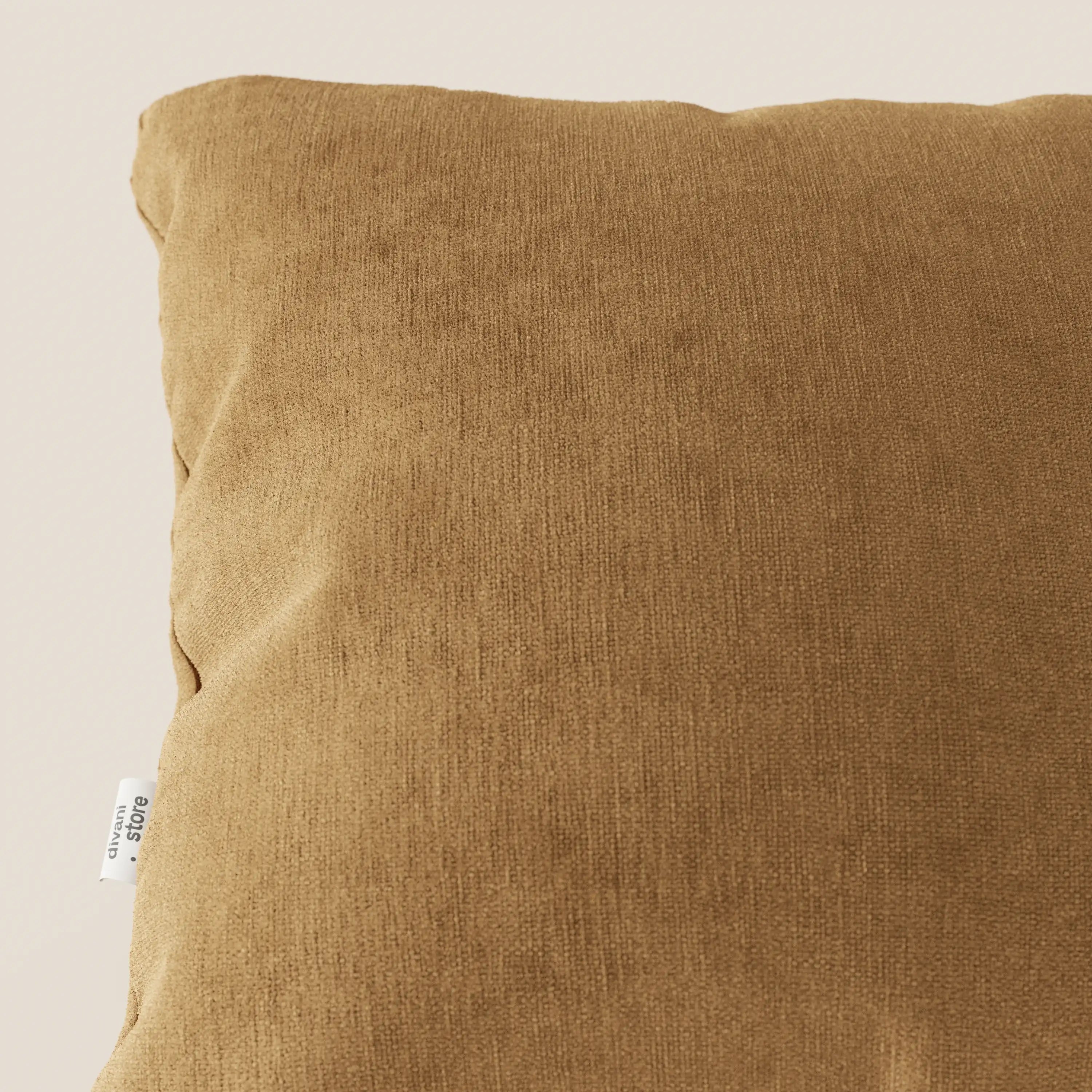 Primo piano del cuscino Bolero quadrato marrone di Divani.Store, realizzato in morbido tessuto T31 antimacchia, impermeabile e non restringente. Una piccola etichetta bianca si trova sulla cucitura laterale. Lo sfondo chiaro evidenzia la consistenza del cuscino.