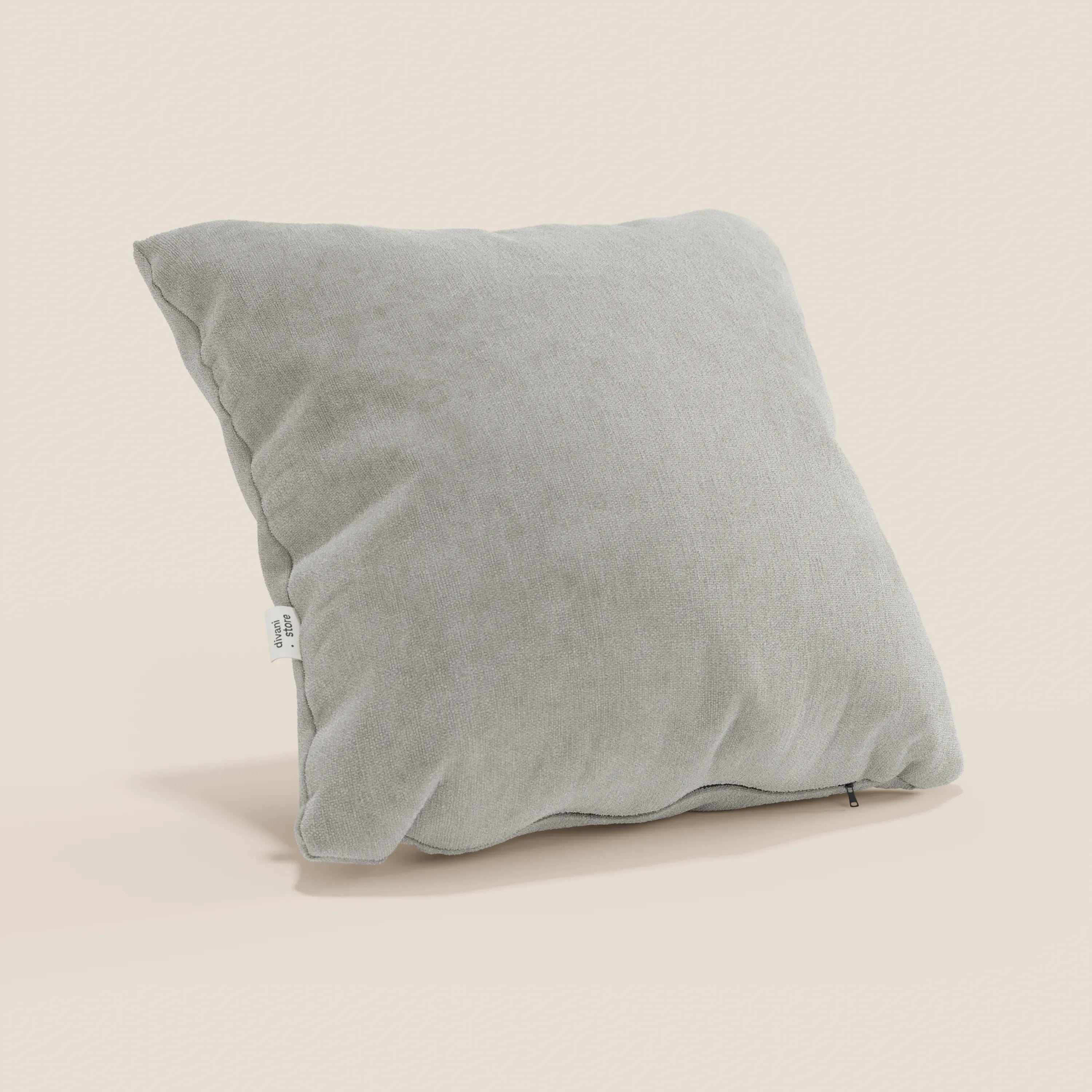 Il cuscino Bolero di Divani.Store, in morbido tessuto grigio chiaro T31 antimacchia, impermeabile e non restringente, è quadrato e verticale su sfondo beige. Lungo il bordo sono visibili una targhetta bianca e una sottile cerniera. Disponibile in vari colori.