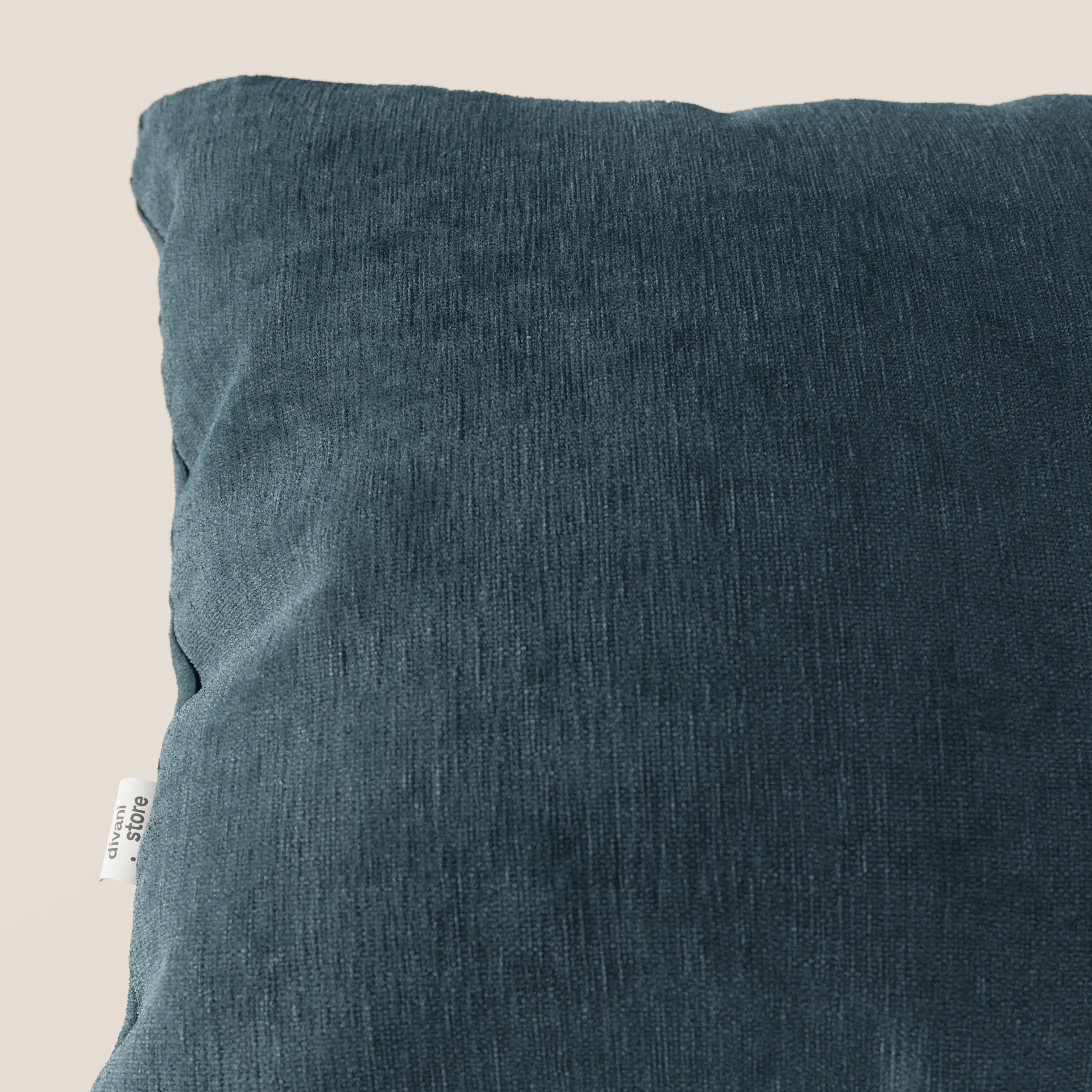 Primo piano del cuscino Bolero di Divani.Store in colore verde scuro, caratterizzato da un morbido tessuto T31 antimacchia, impermeabile e non restringente. Una piccola etichetta bianca appare a sinistra su uno sfondo beige chiaro che evidenzia il cuscino.
