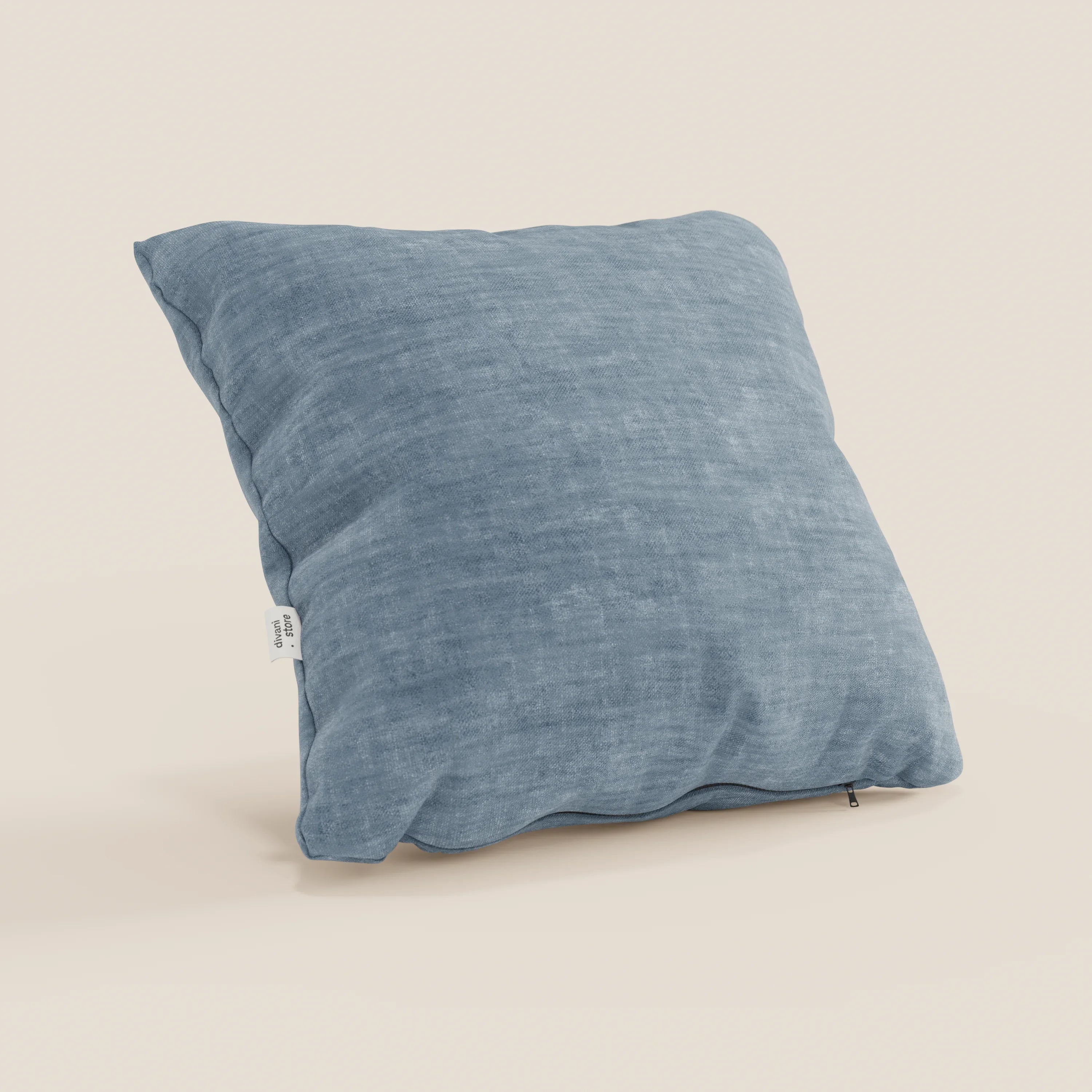 Il cuscino Sofia di Divani.Store, in velluto nuvolato smacchiabile e impermeabile Easy Clean T35, è proposto in vari colori. Qui è raffigurato nella versione azzurra con zip sul bordo inferiore e piccolo tag laterale su sfondo beige.
