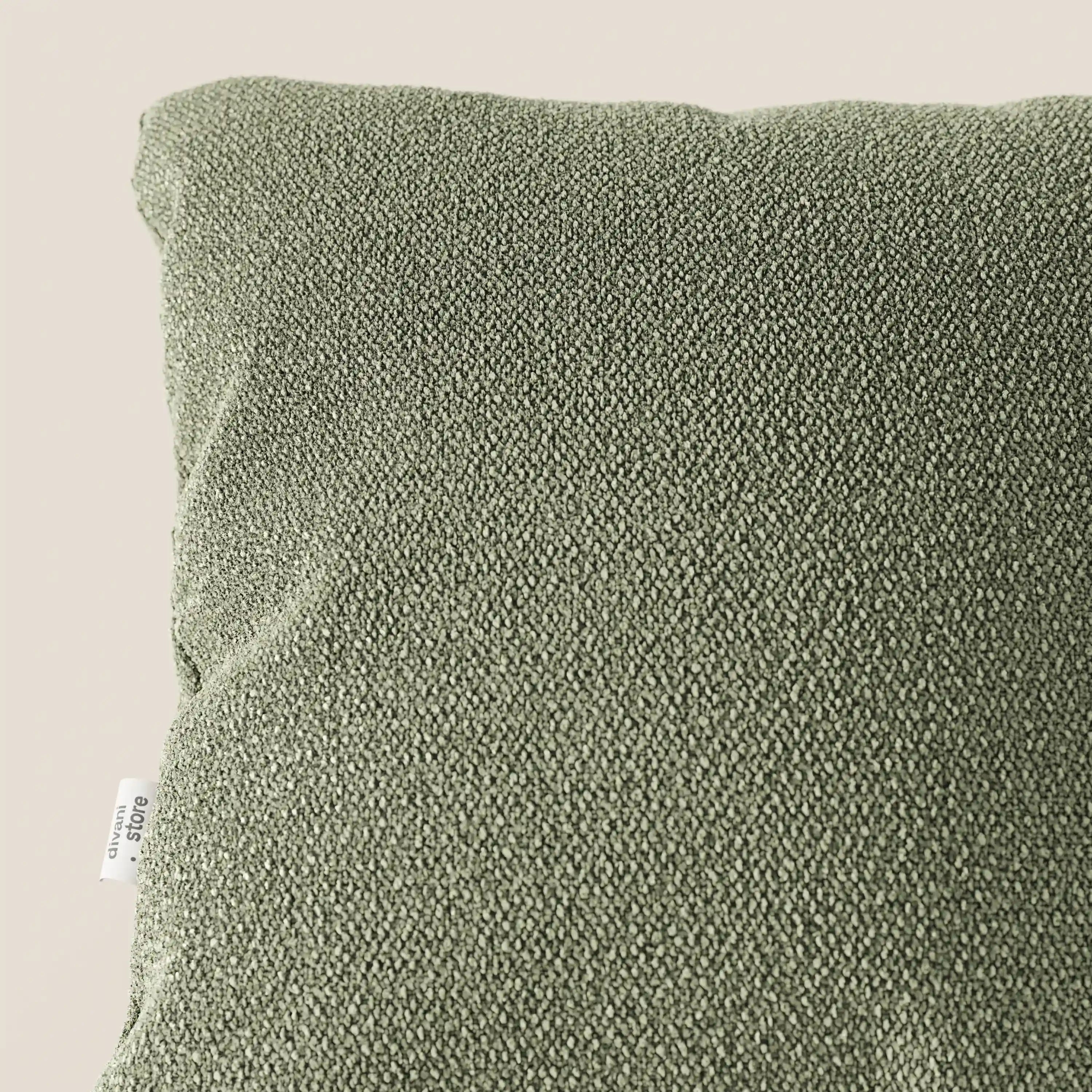 Primo piano del cuscino Lambada di Divani.Store in verde oliva, realizzato in tessuto fresco e naturale T33 antimacchia e impermeabile, visto dall'alto su sfondo beige con etichetta bianca visibile in basso a sinistra.