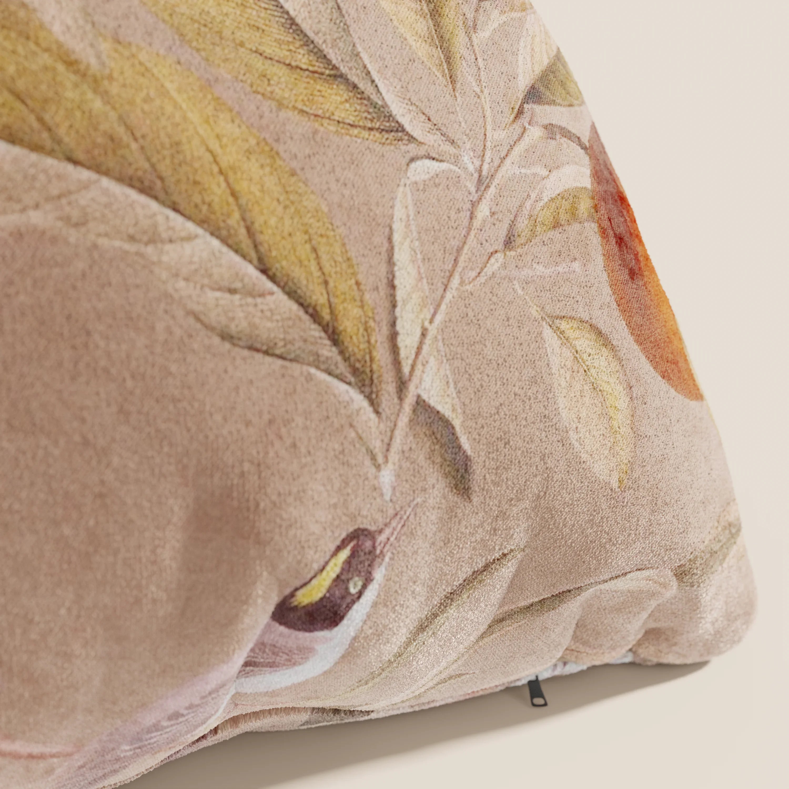 Primo piano dell'elegante collezione di cuscini a fantasia Divani.Store Lemon in velluto impermeabile salmone, con foglie verdi e gialle, un frutto arancione e un uccellino. Questo cuscino decorativo lavabile aggiunge fascino al vostro spazio.