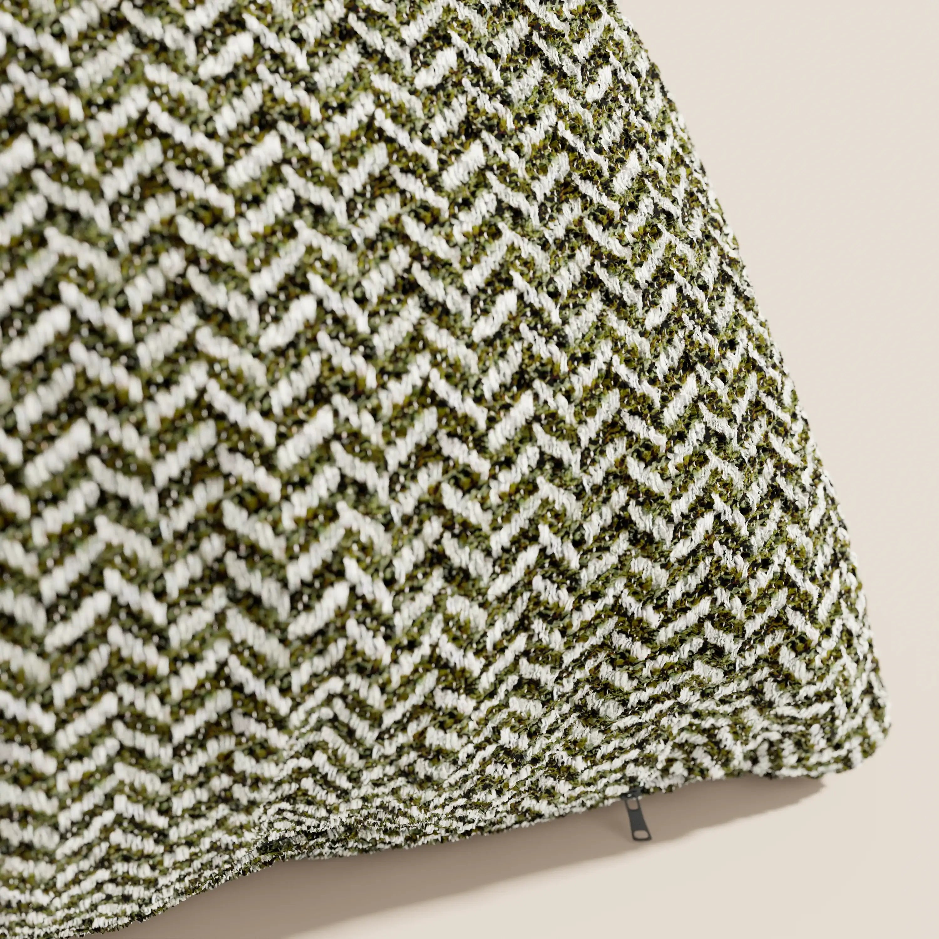 Primo piano del cuscino Sorrento 45x45 in lino di Divani.Store, che mette in risalto la trama a zig-zag verde e bianca. Appartenente alla nostra linea di cuscini lavabili in lavatrice, presenta una cerniera a vista su un lato.