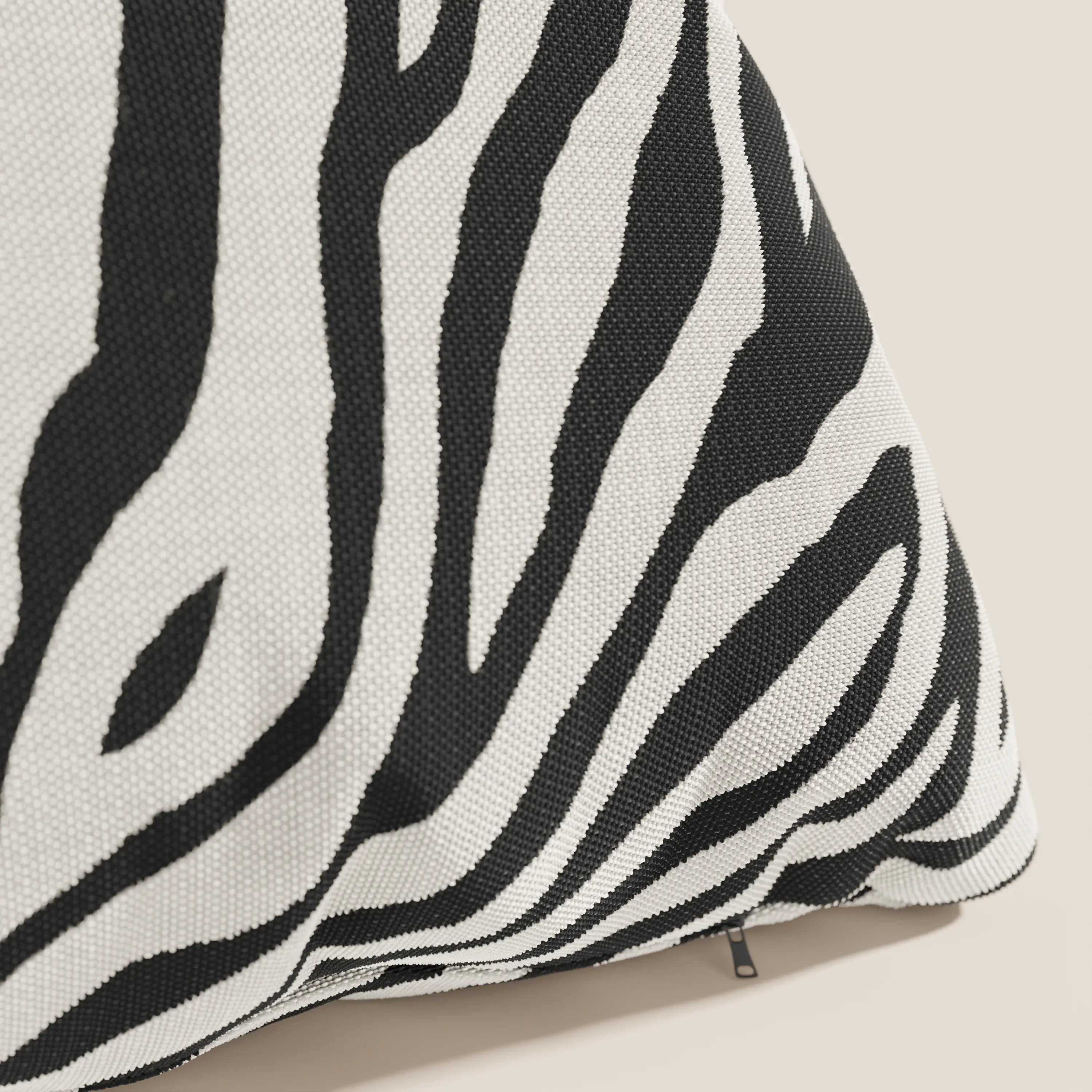 Primo piano dello Stripe cuscini geometrici in tessuto idrorepellente di Divani.Store, caratterizzato da audaci strisce zebrate bianche e nere, una cerniera a vista e un intreccio strutturato, mostrato su uno sfondo neutro per enfatizzare il suo design sorprendente.