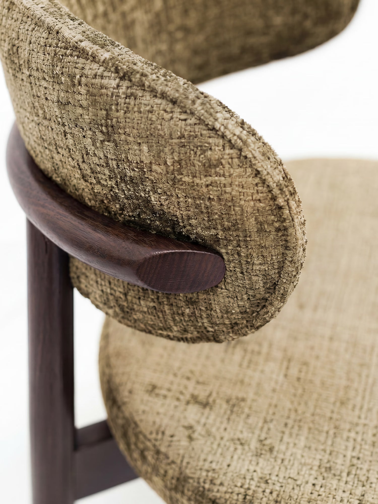 Primo piano della sedia imbottita Dafne di Divani.Store, caratterizzata da schienale e seduta imbottiti e sinuosi in ciniglia certificata OEKO-TEX®, con struttura in legno massello di wengé e profili arrotondati, raffigurata su sfondo bianco.