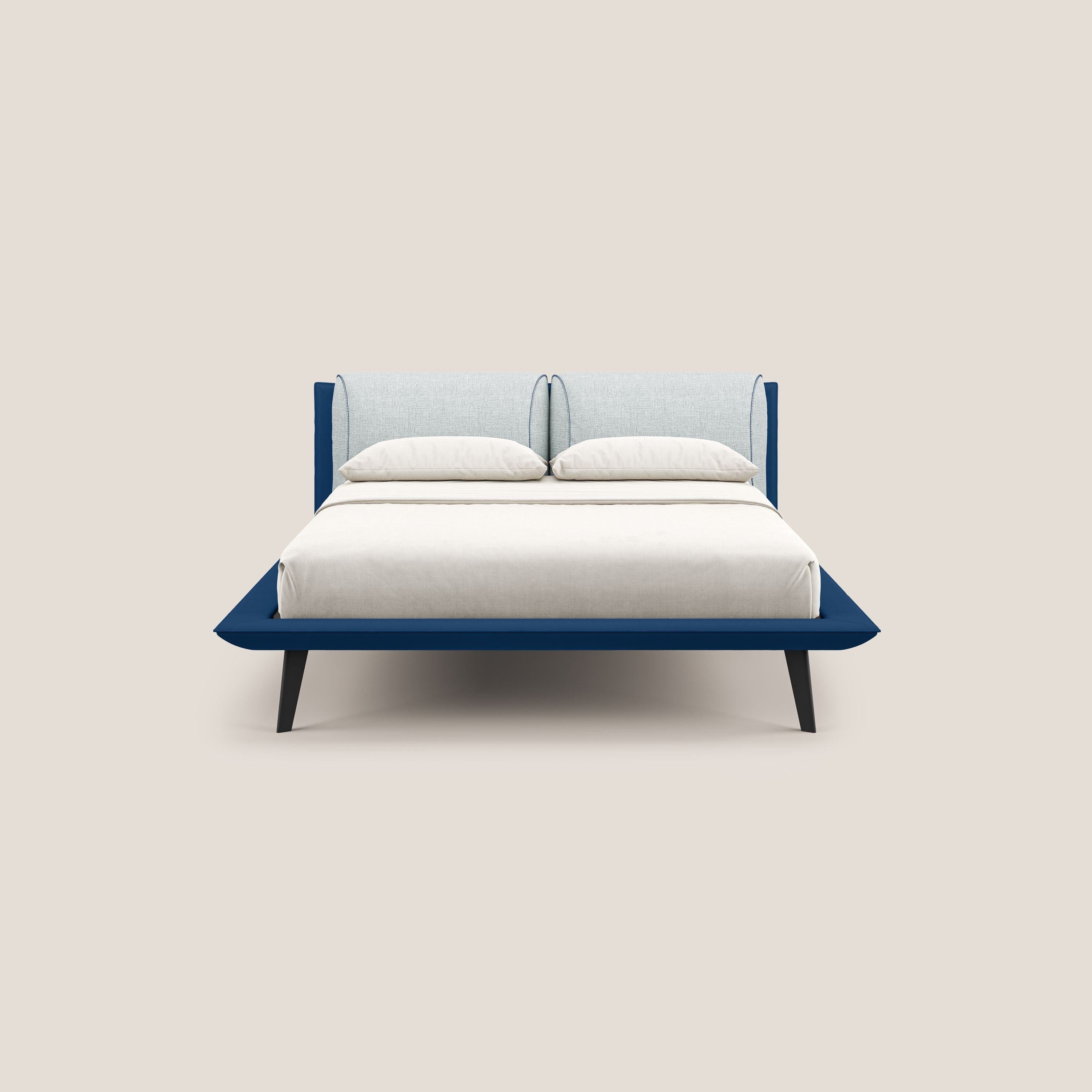 Il letto di design Petra di Letti.store è caratterizzato da un tessuto bicolore blu-ghiaccio impermeabile T11/T06, cuscini in piuma, testata grigio chiaro, struttura blu scuro e gambe mogano. È fotografato con un piumino bianco sporco su sfondo beige.