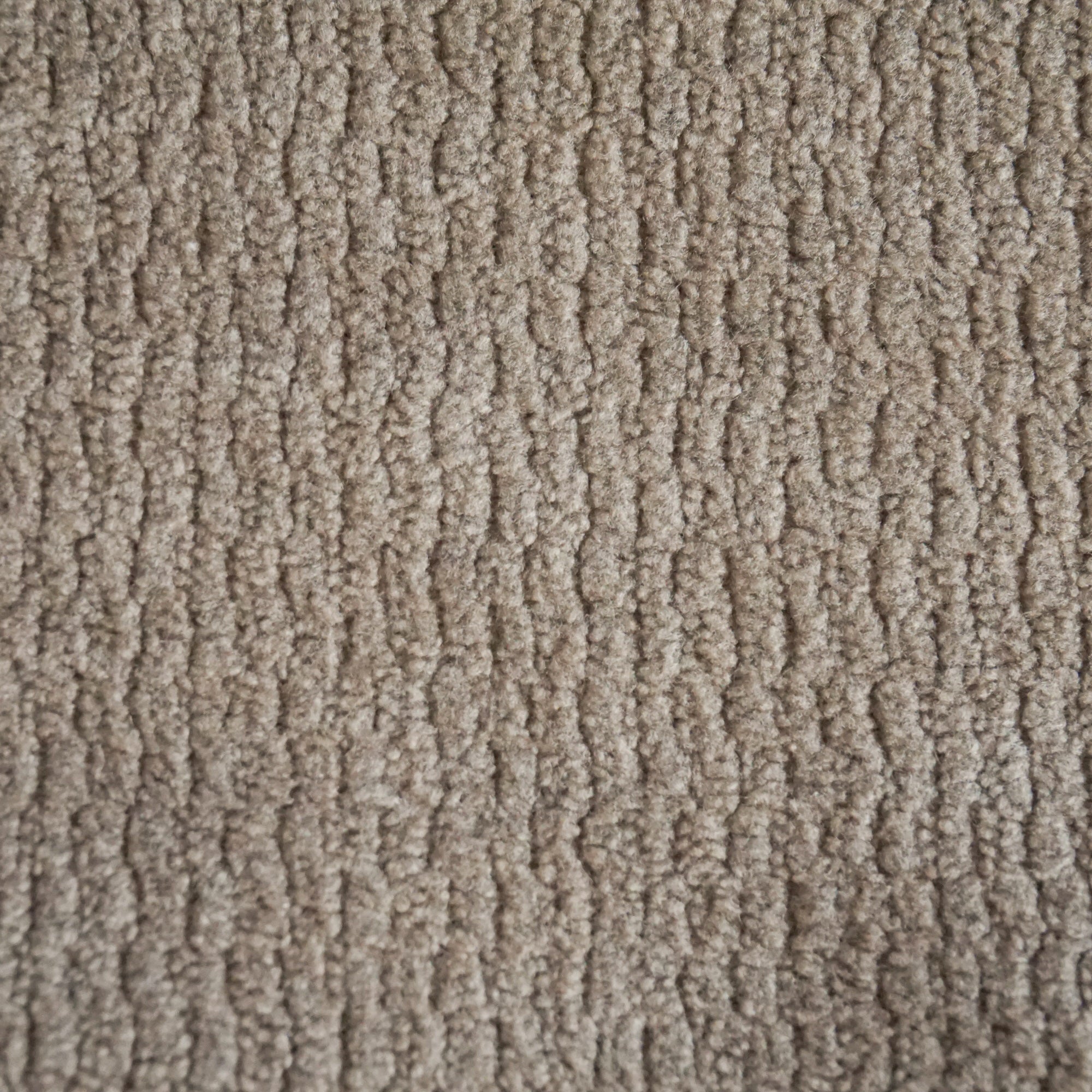 Primo piano del tessuto morbido T32 Kendal di Divani.Store, caratterizzato da un motivo ad anello con righe ondulate nei toni del beige. Il tessuto è impermeabile, resistente alle macchie e offre una superficie ammortizzata con sottili variazioni di colore.